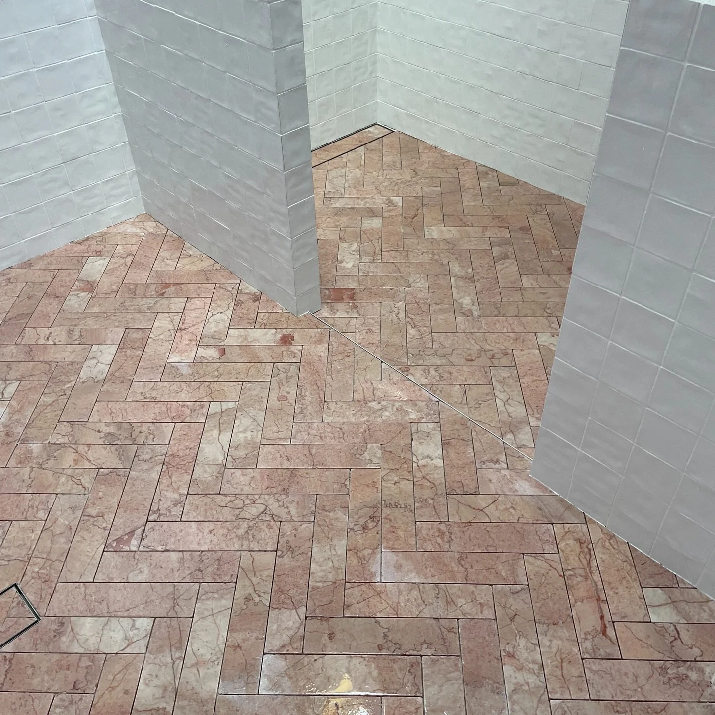 Stone tiles laid in herringbone pattern, paired with handmade wall tiles.
Swipe for waterproofing flood test 

Completed as site manager for @robertplumb.fix 
Interior design | @brionyfitzgeralddesign