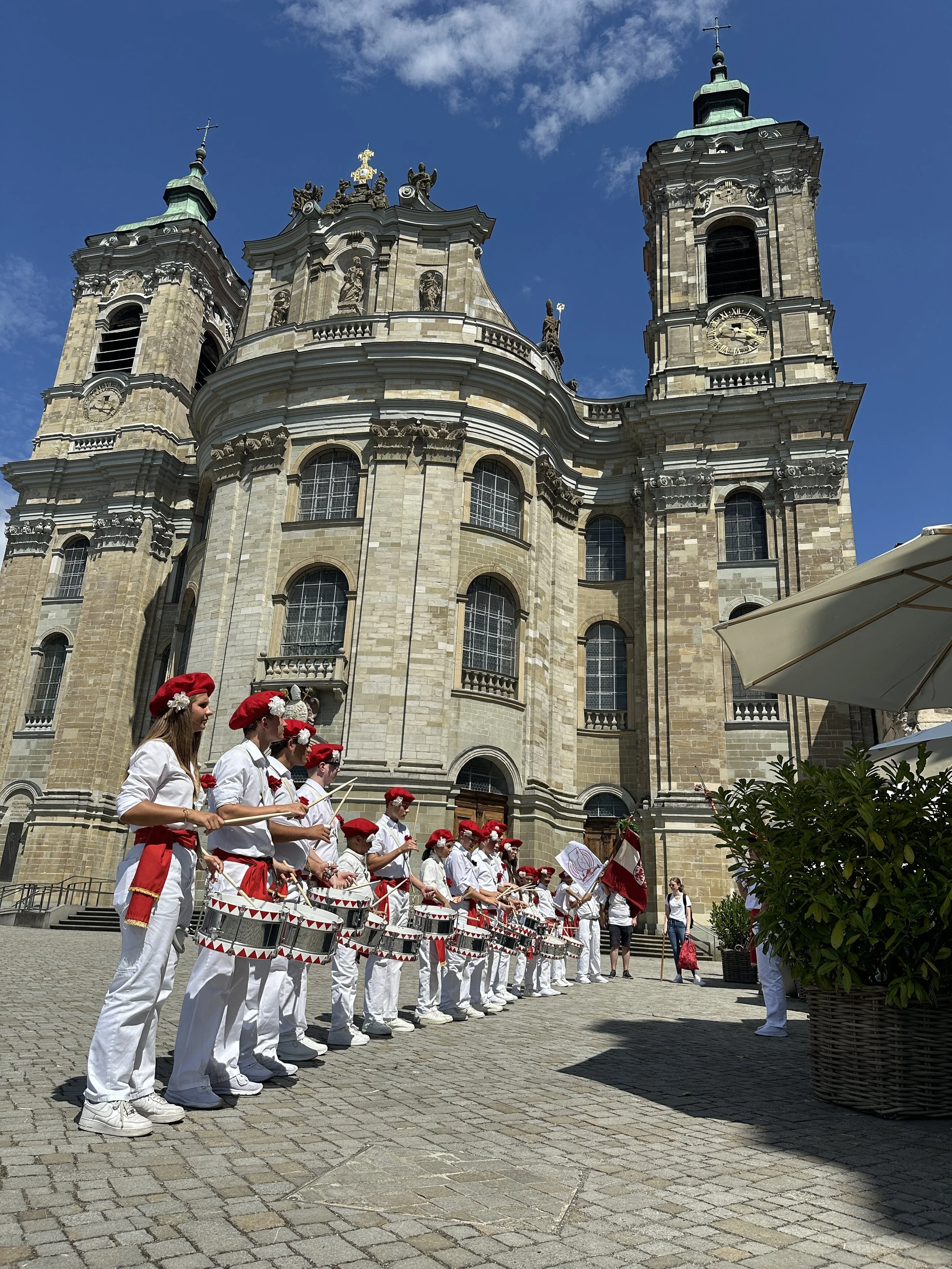 Gruppe von Menschen in weißen Kleidern vor dem Martinus.