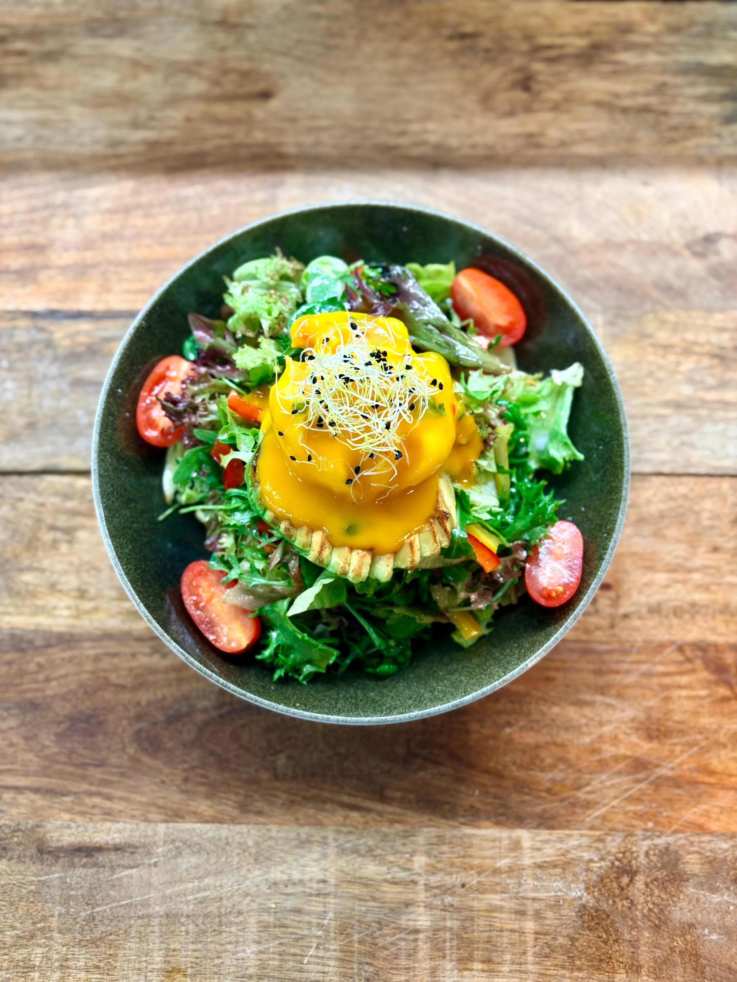 Essen im Martinus in Weingarten: Gemischter Salat mit Tomaten, Salatblättern, und einer metaphorisch aussehenden aufgeschnittenen Mango mit Frischkäse und Alfalfa-Sprossen
