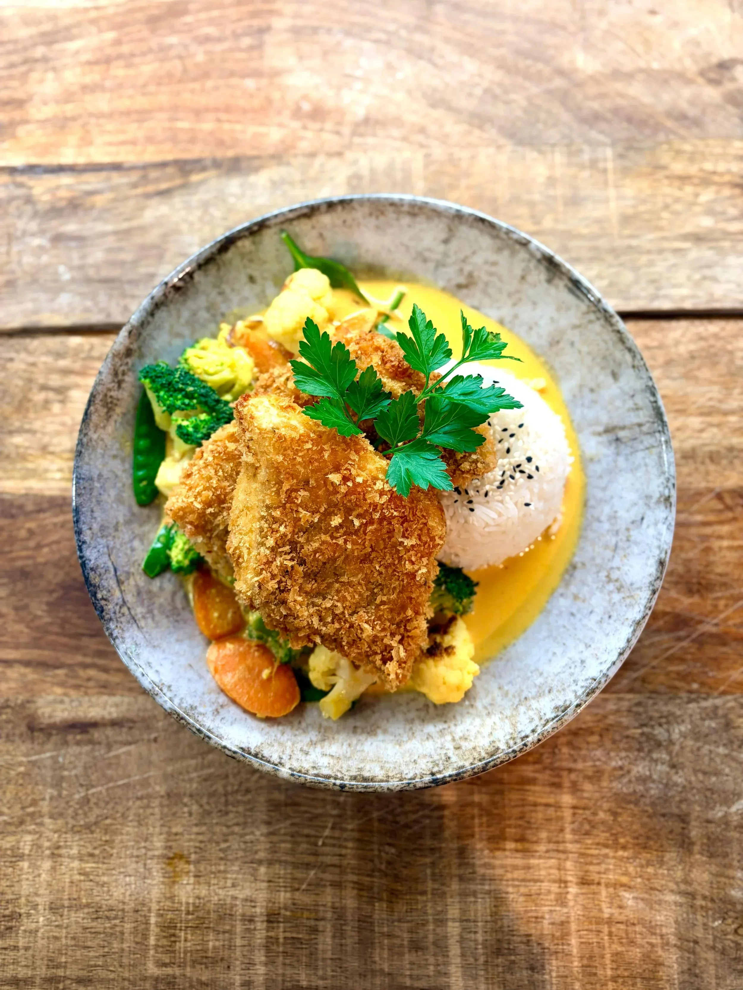 Essen im Martinus: Fischfilet mit Currysoße, Reis, Brokkoli, Karotten und einem grünen Kräuterblatt