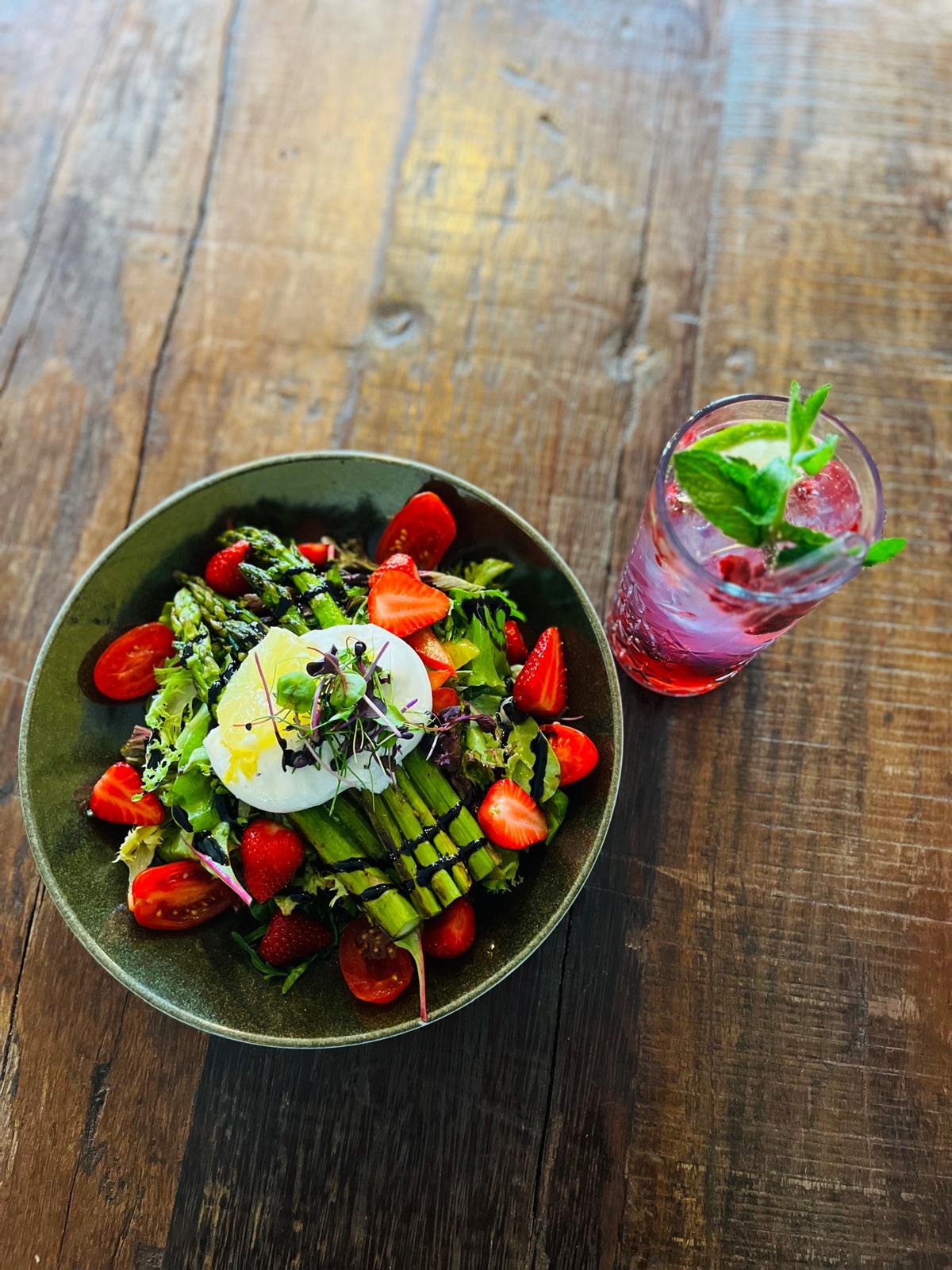 Essen im Martinus in Weingarten: Salat mit Ei, Tomaten und Spargel, daneben ein Glas mit Getränk und Minzblättern