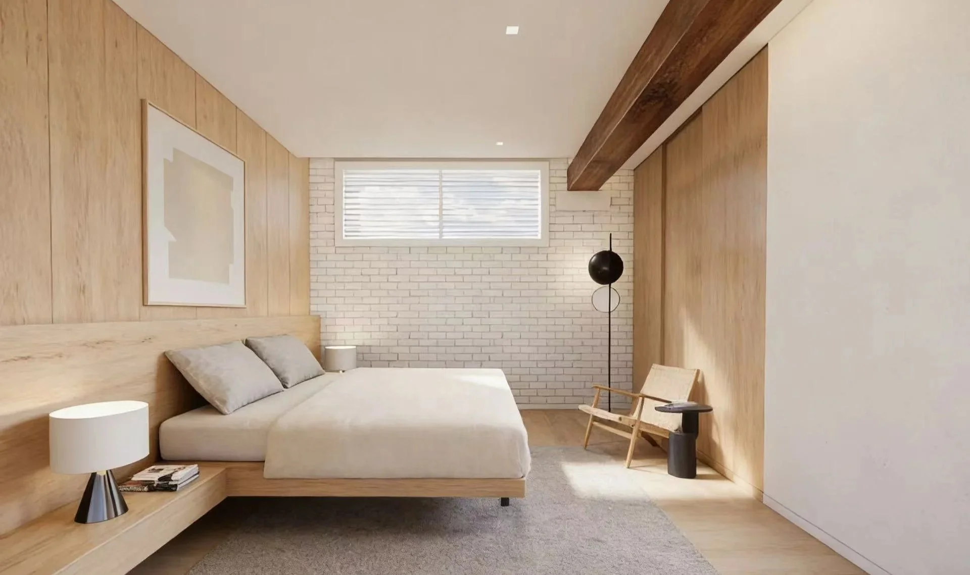 Minimalist bedroom with wood-paneled walls, a white brick accent wall, a large window with blinds, a bed with gray pillows, a nightstand with a lamp and magazines, a black floor lamp, a beige armchair, a small side table, and a floor rug.