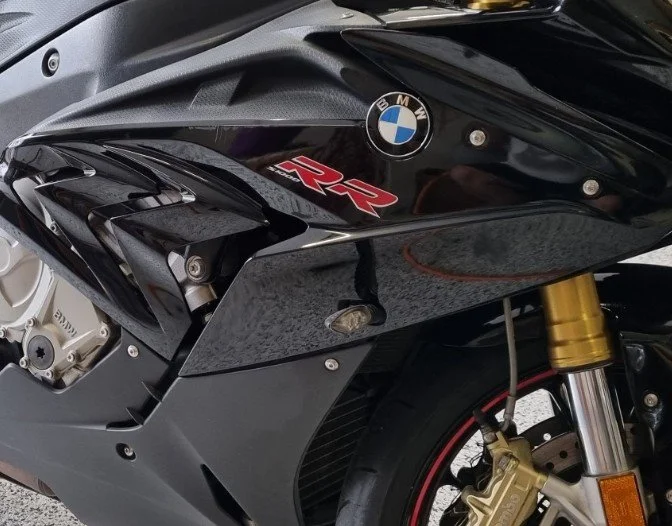 Close-up of a black BMW motorcycle with a red 'RR' logo and a gold front fork.