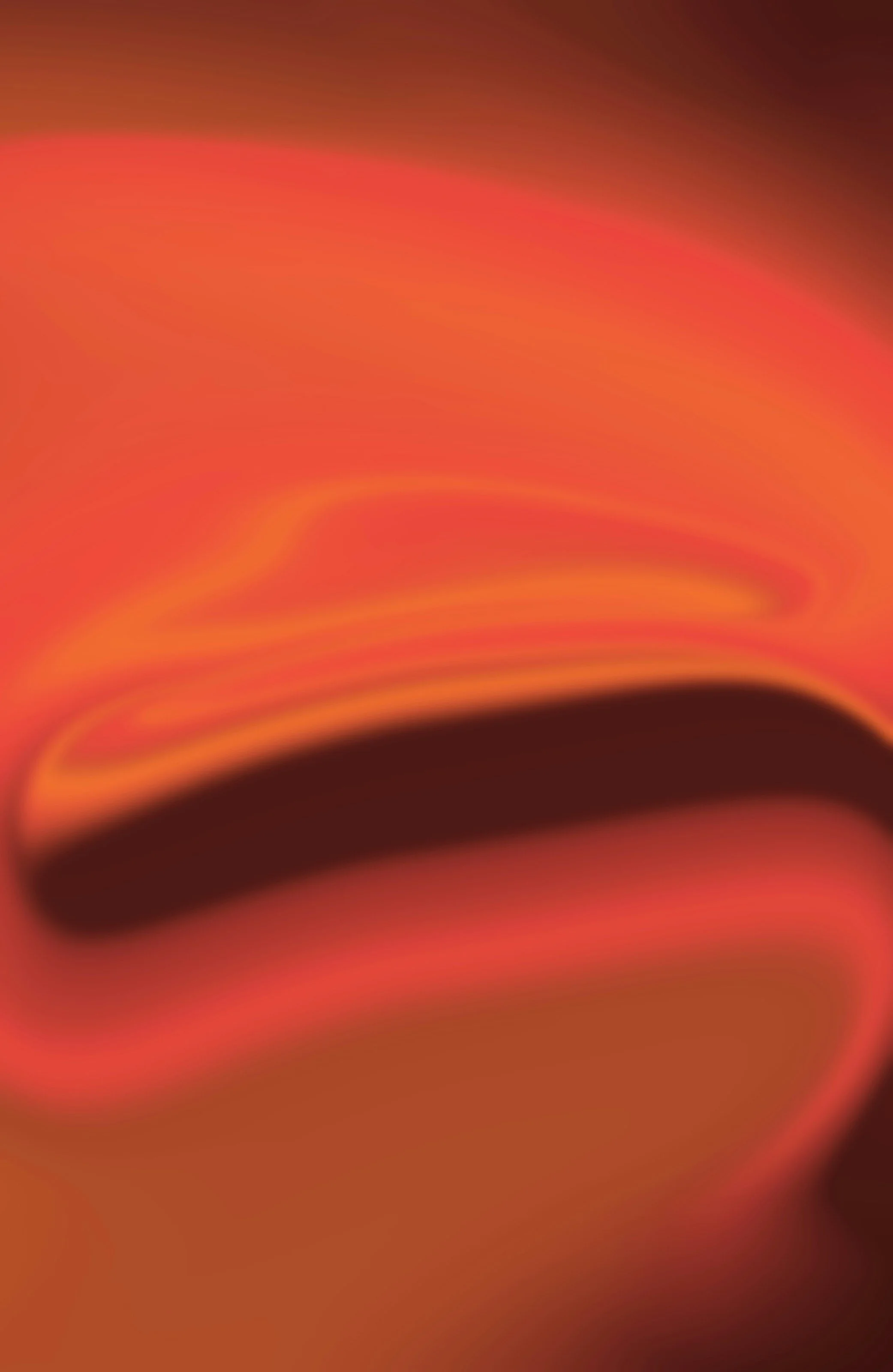 An abstract, blurred image with warm colors, predominantly pink, orange, and black.