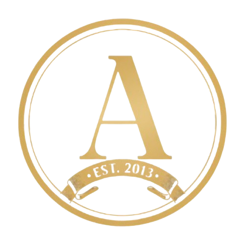 The Ashalon Gold-colored circular emblem with the letter 'A' centered. Below the letter, there is a ribbon banner with the text 'EST. 2013'.