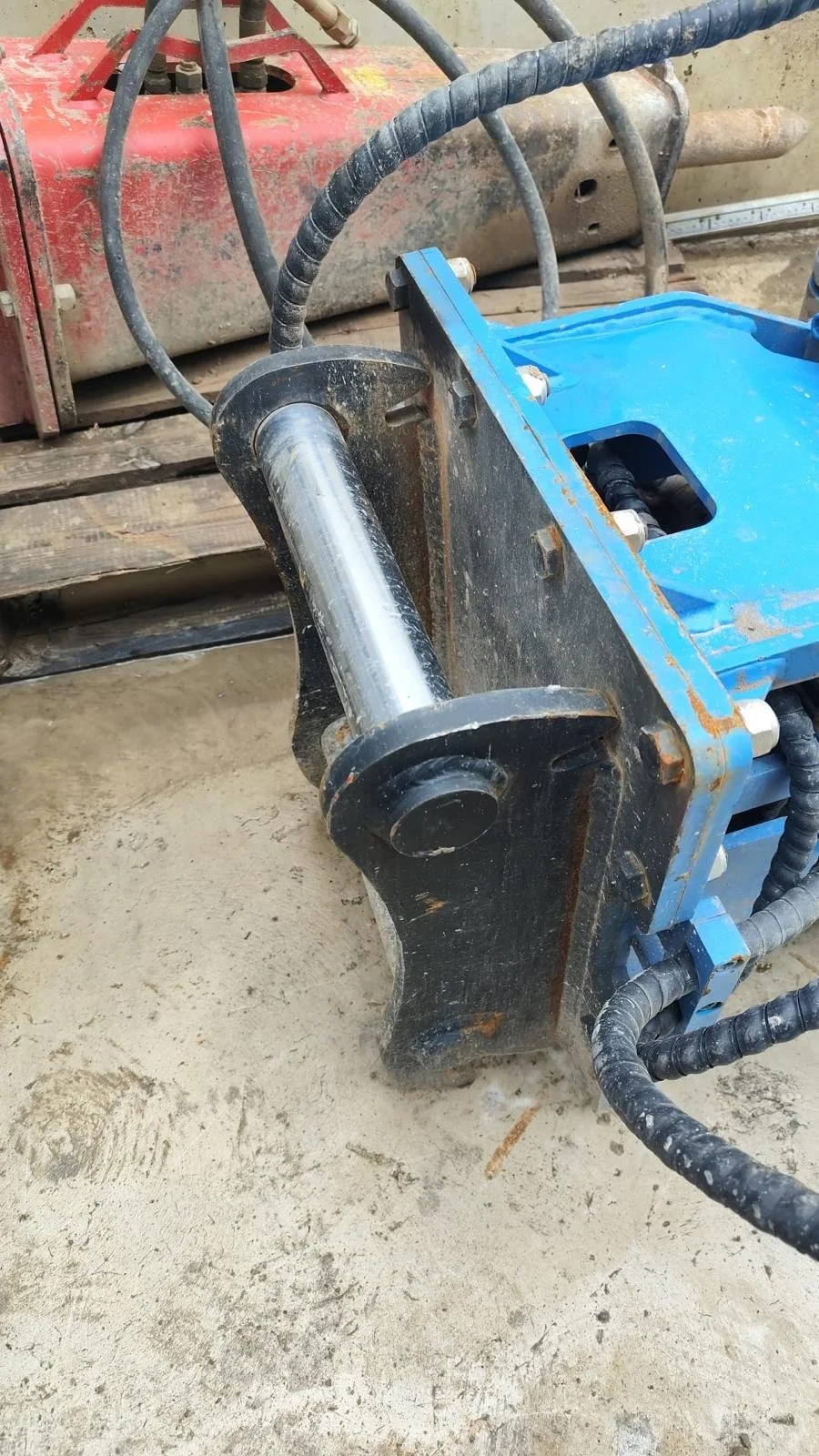 Mecanismo hidráulico con componente metálico y cables en un ambiente de construcción.