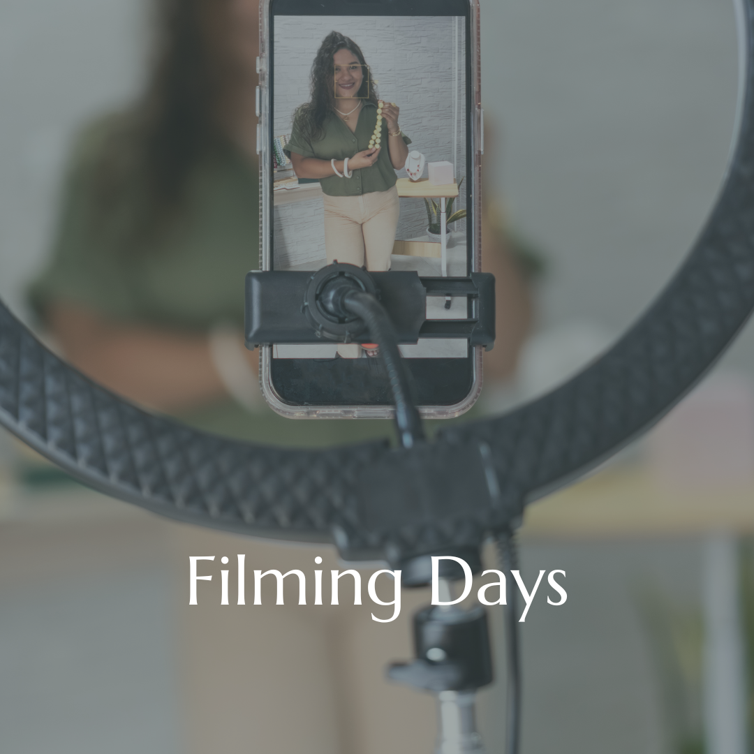 A woman is being filmed, holding a beaded necklace, and smiling. The video is shot through a ring light with the text "Filming Days" overlaid.