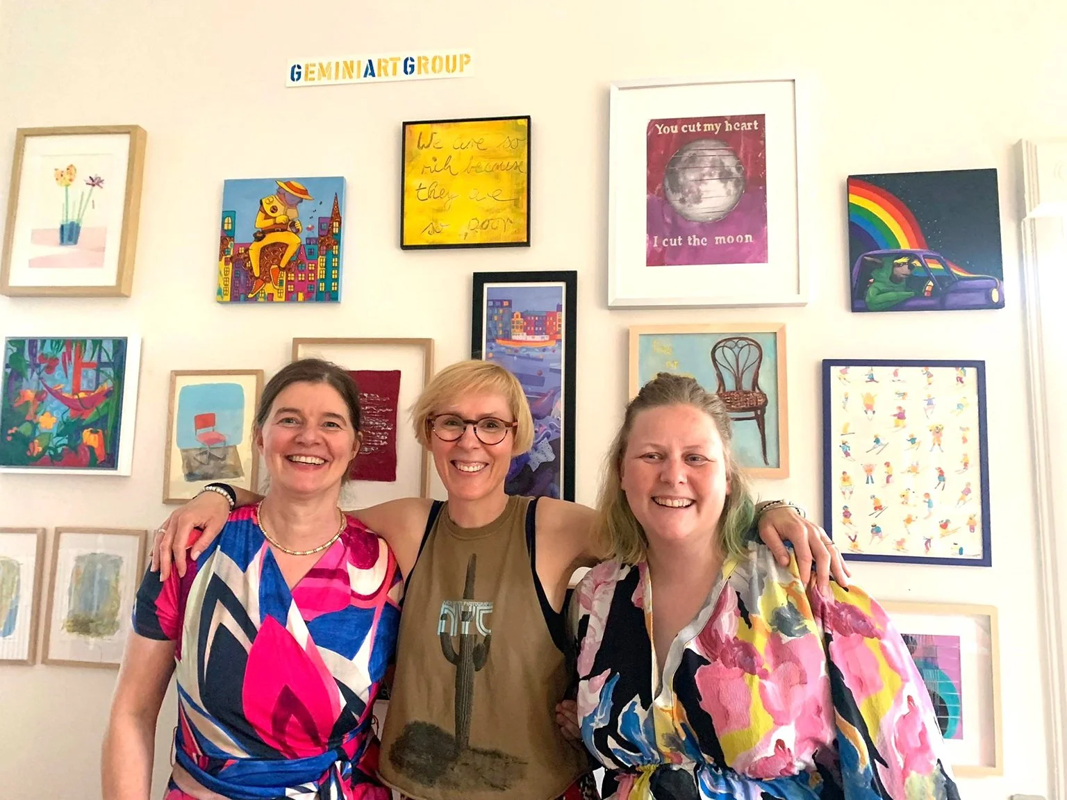 A photo of the 3 members of the Gemini Art Group standing in front of their frames artwork.