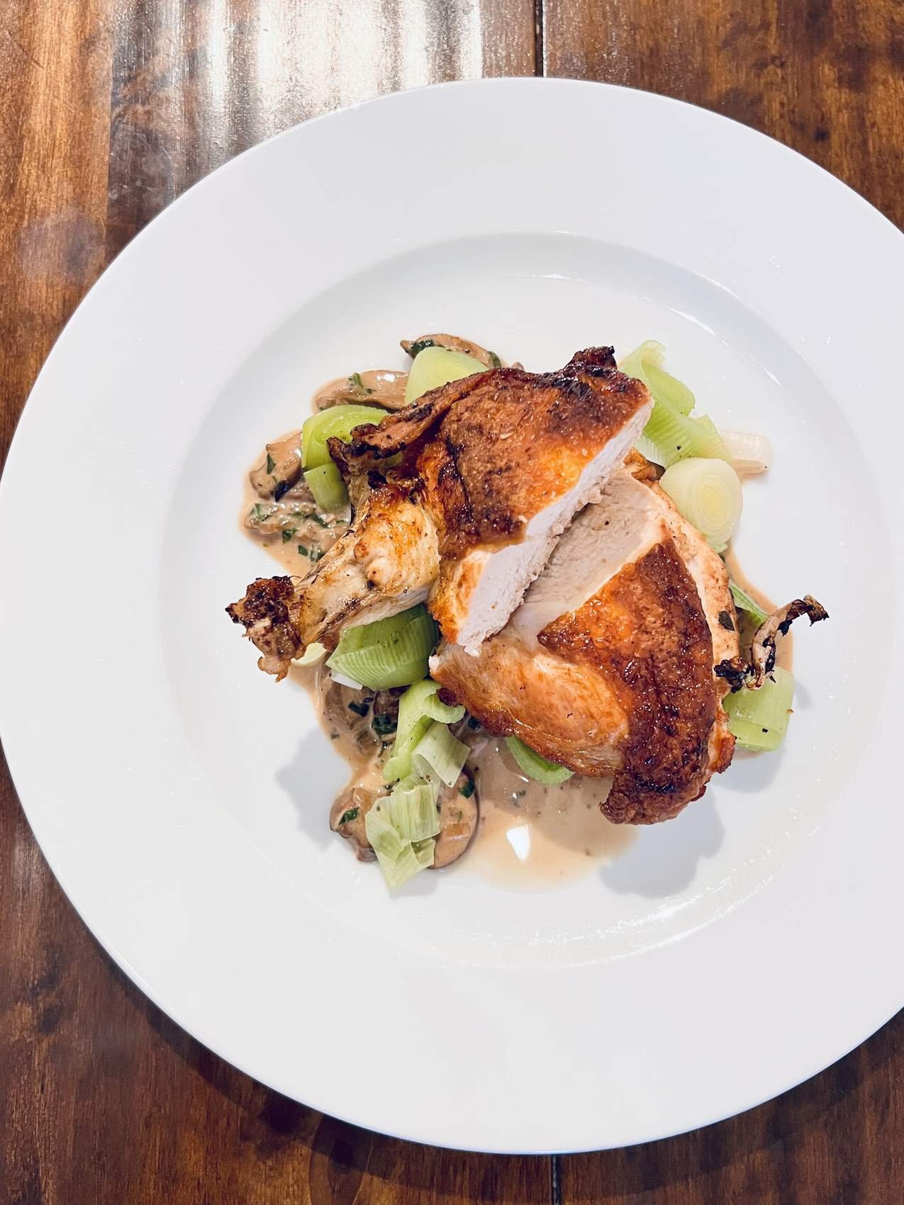 Pan-roasted chicken breast with a mushroom and leek cream sauce.