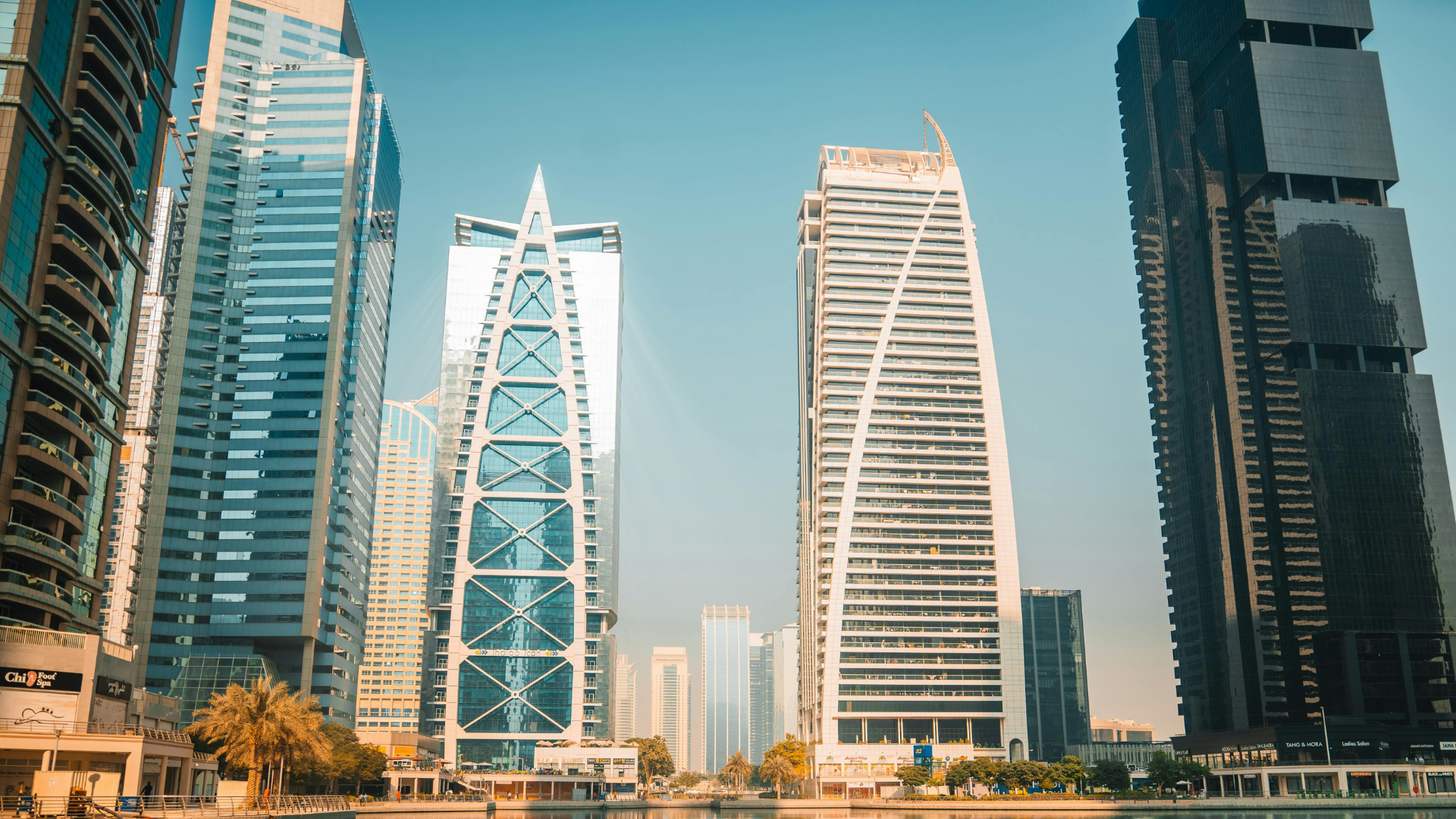 A city skyline with tall modern skyscrapers and high-rise buildings against a clear blue sky.