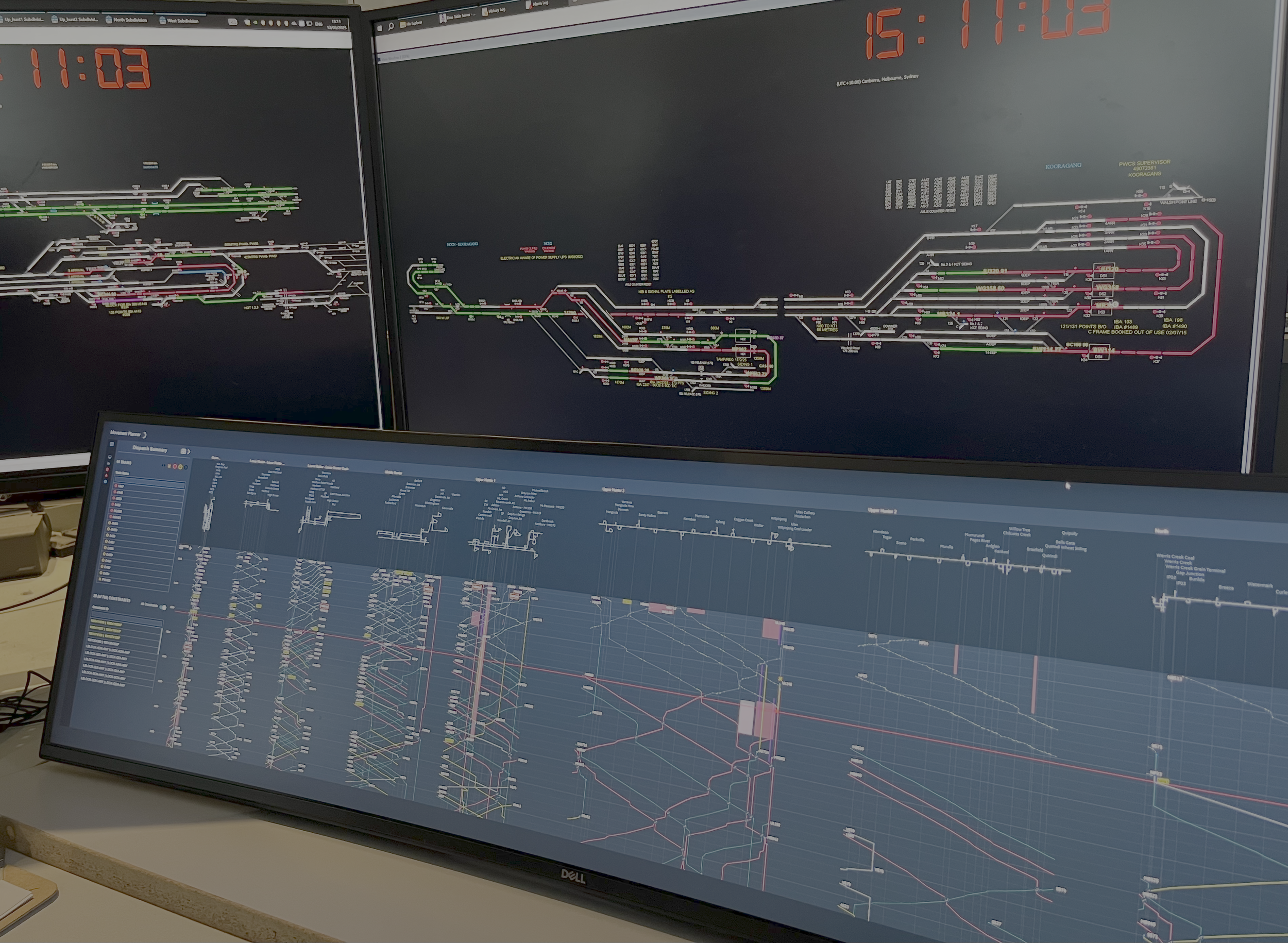 Computer monitors displaying detailed electrical and subway network diagrams with timetable and system information. Copyright of Stephanie Munns Heilsa Consulting Pty Ltd