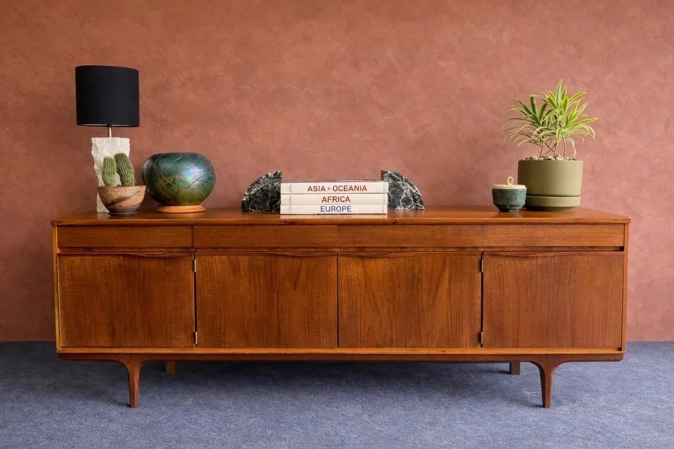 SOLD

Austinsuite Teak Sideboard, Great Britain, circa 1960s.

By Aassenn (Hutton) Ltd. of London. Four hinged cabinet doors with sculpted teak pulls and brass hinges, over three top drawers with matching pulls. Center bays each have one interior she