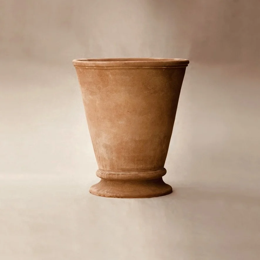 A plain terracotta flowerpot on a neutral background.