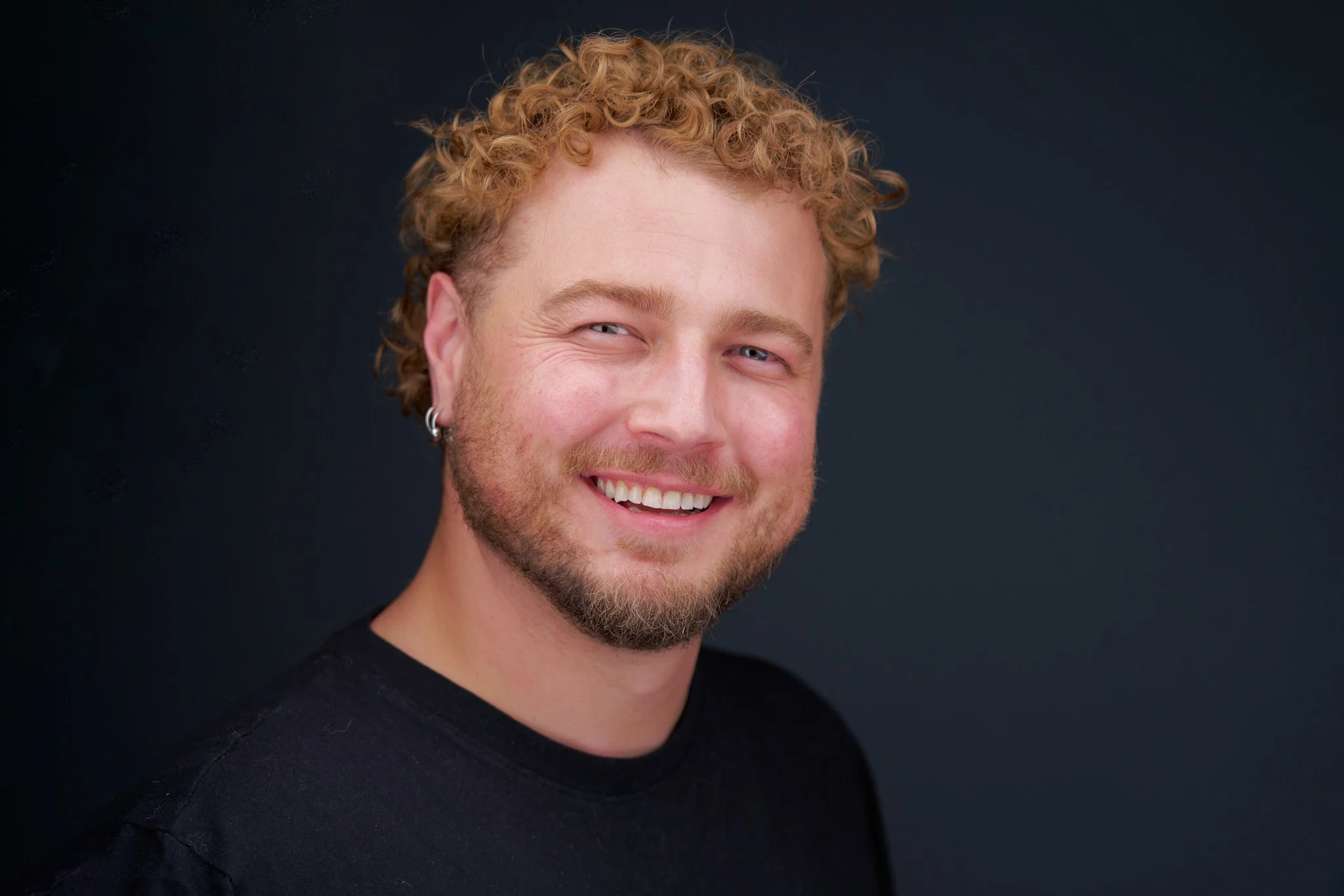 Professional headshot of a smiling man.