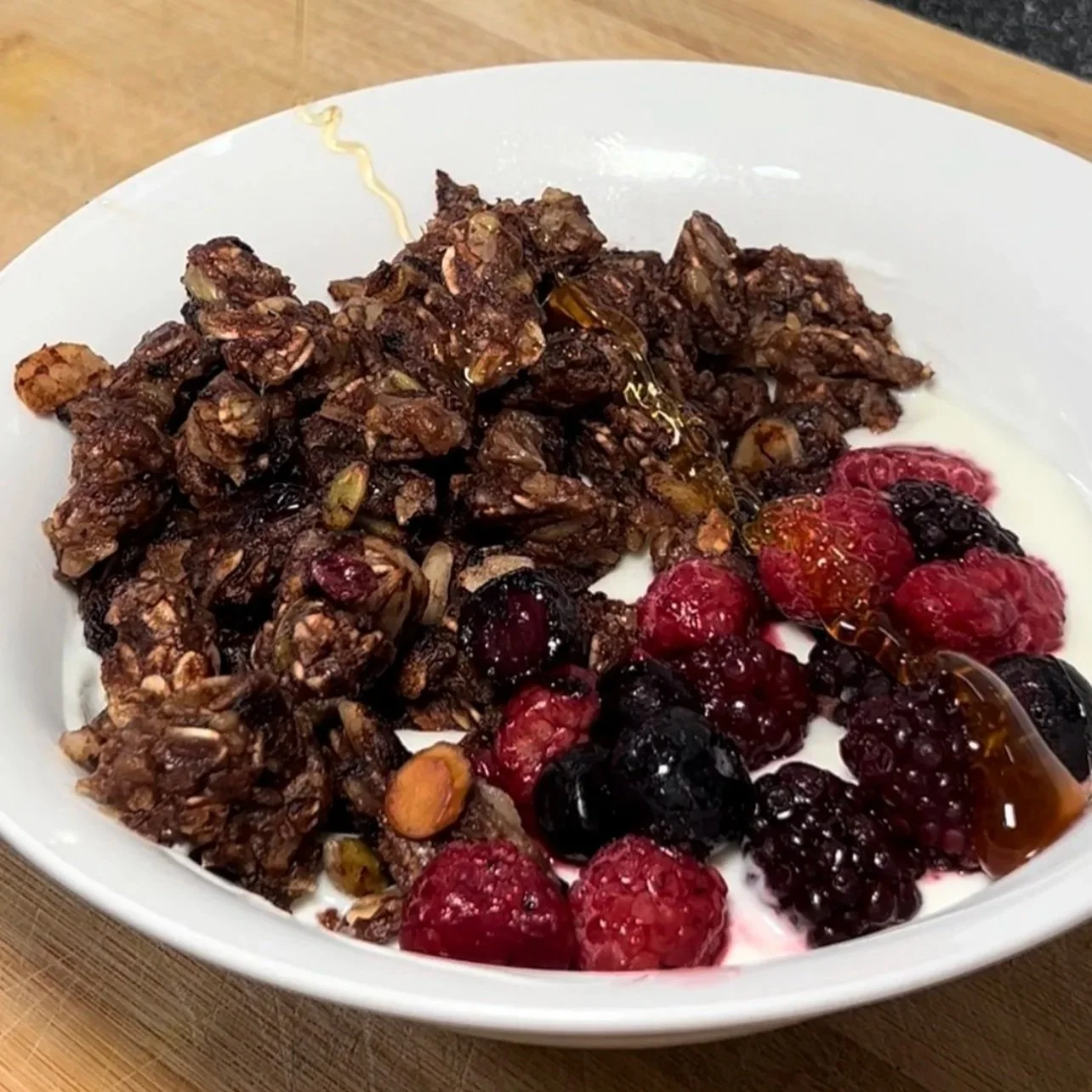 Bowl of granola with fresh berries and honey on top