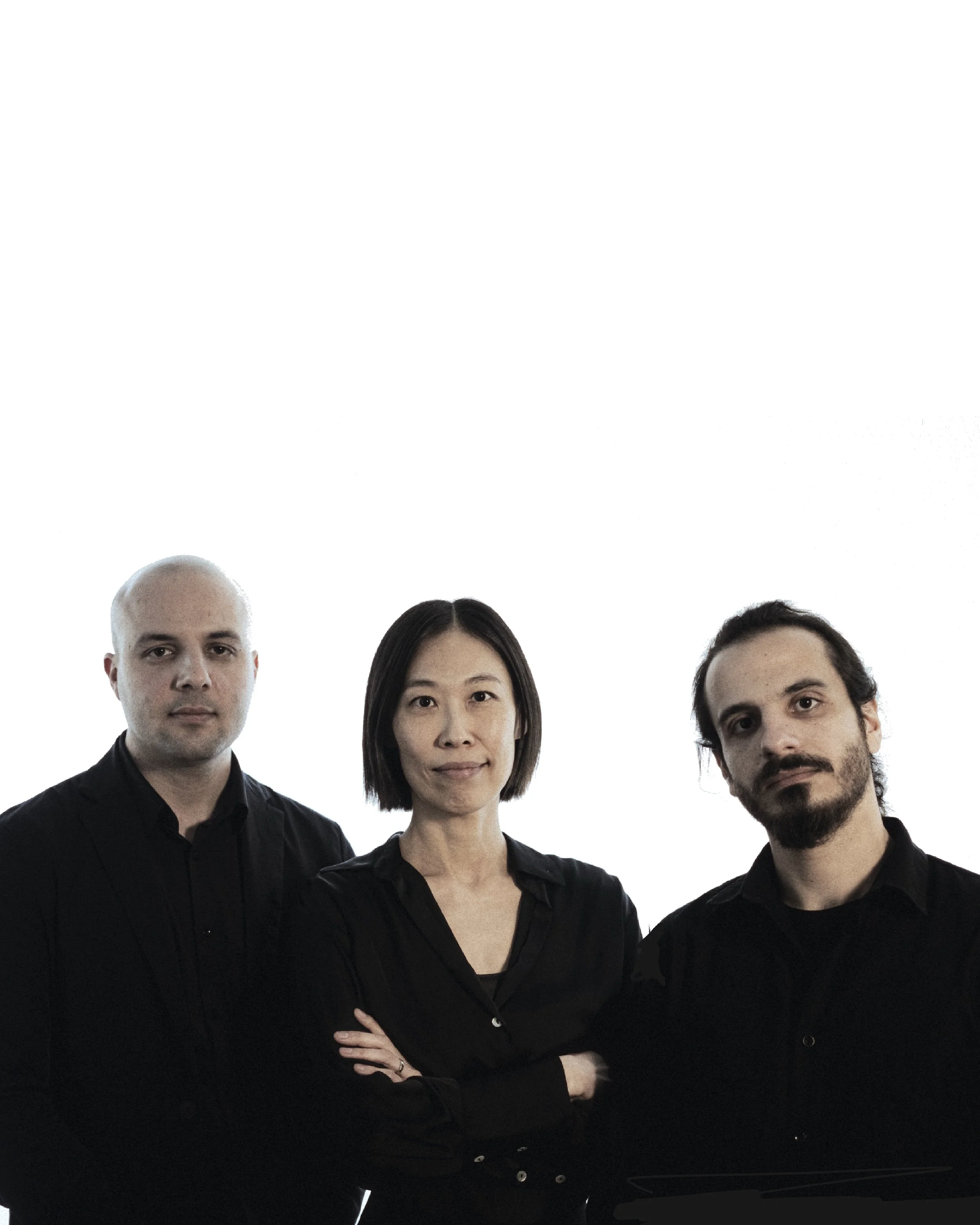 Three people standing with arms crossed, wearing black shirts, against a white background.