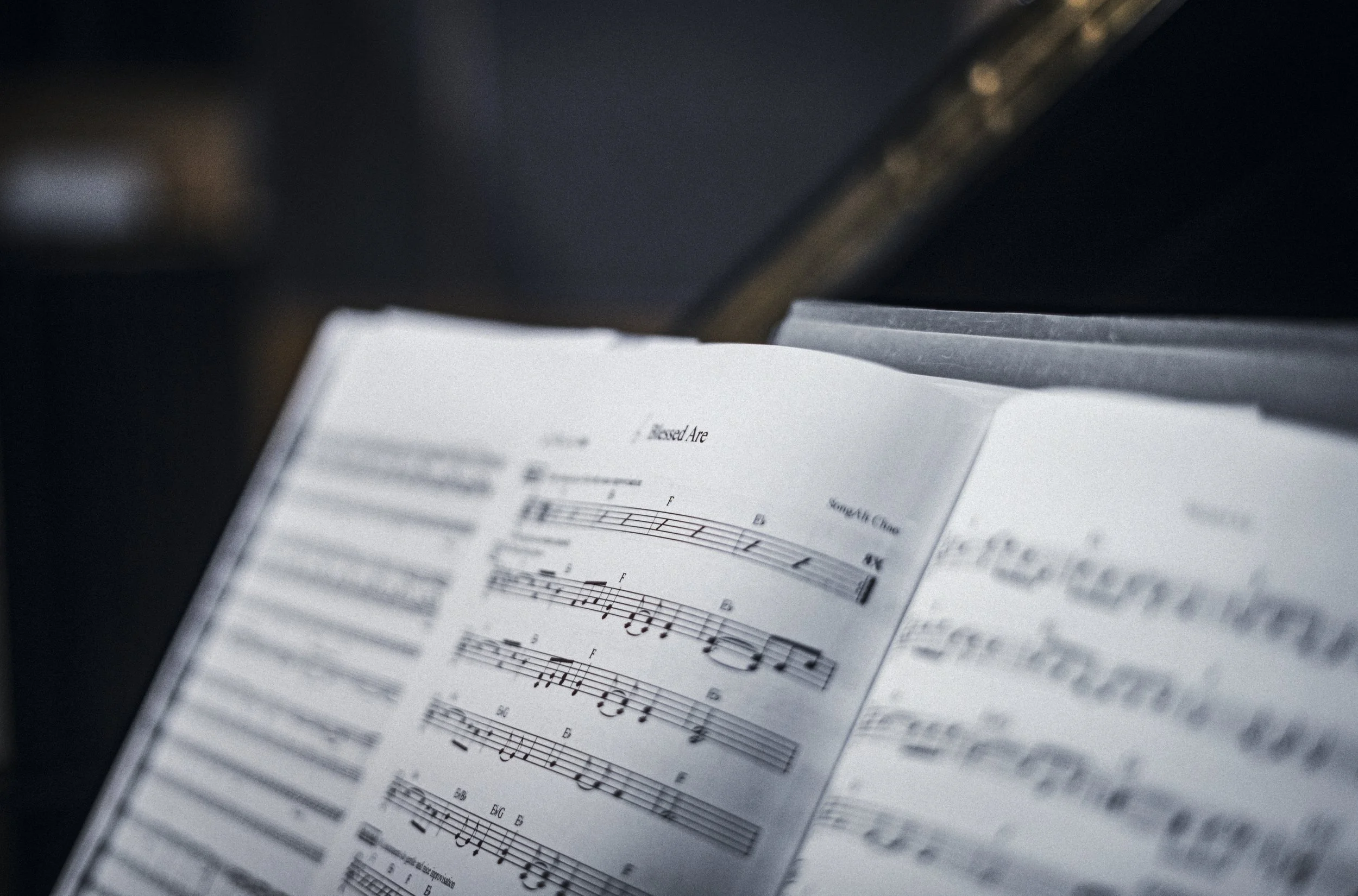 Open music sheet with notes and chords on a piano stand.