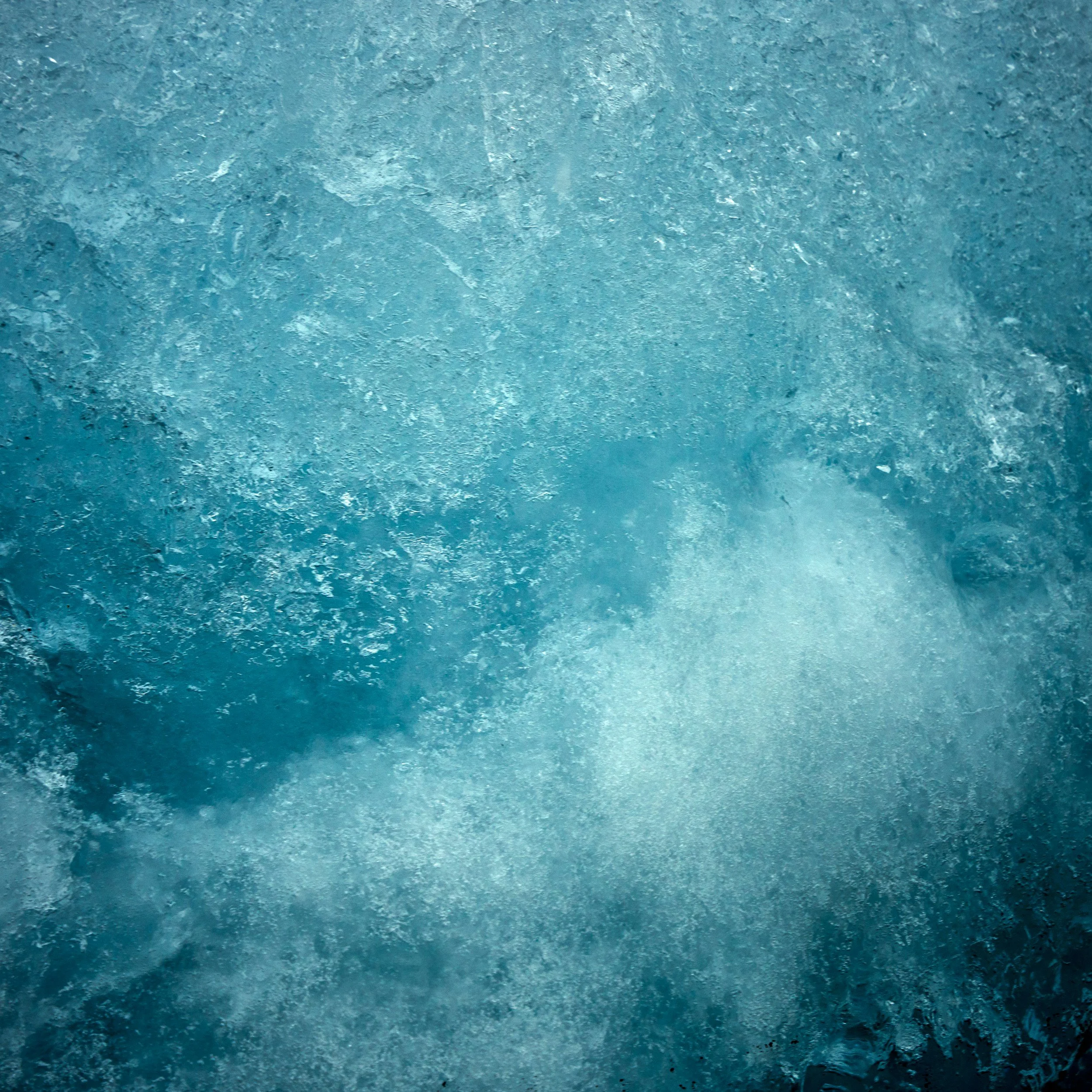 Close-up of icy blue textured surface, resembling frozen water or ice.