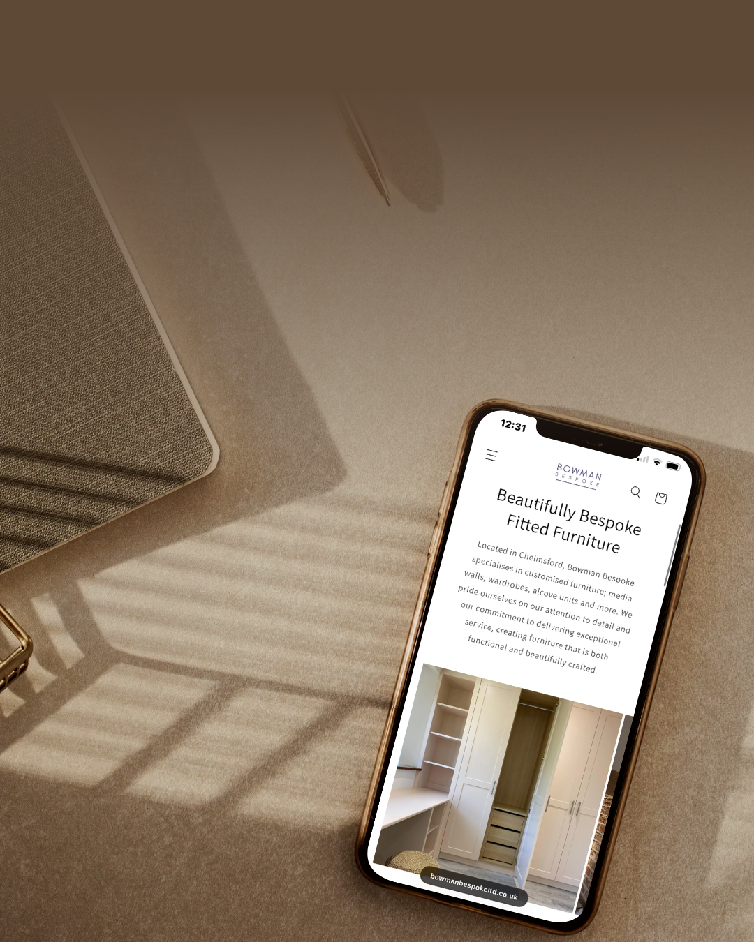 Smartphone displaying a grid of posts or images on a social media app, placed on a beige desk with a pen and textured surface in the background.