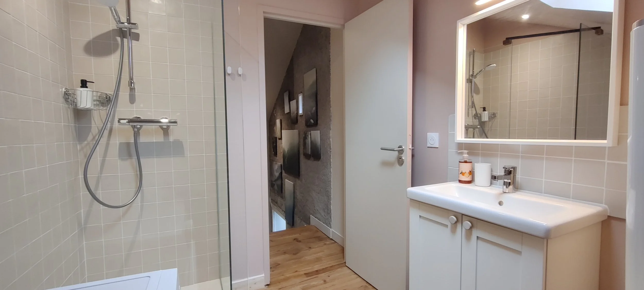 Bathroom with shower, mirror, sink, and cabinets