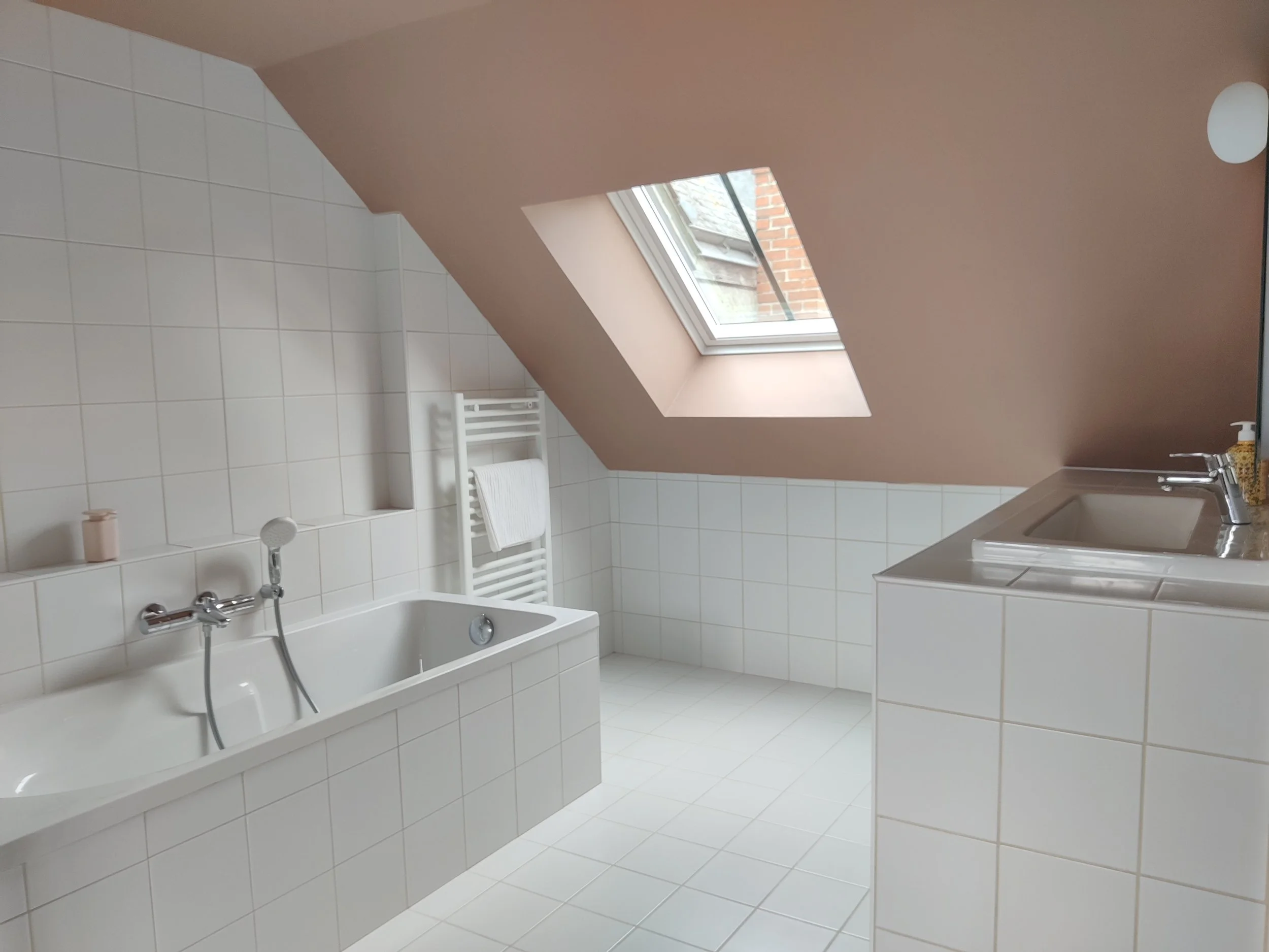 Bedroom, white bed, red pillows, painting, wreath on the wall