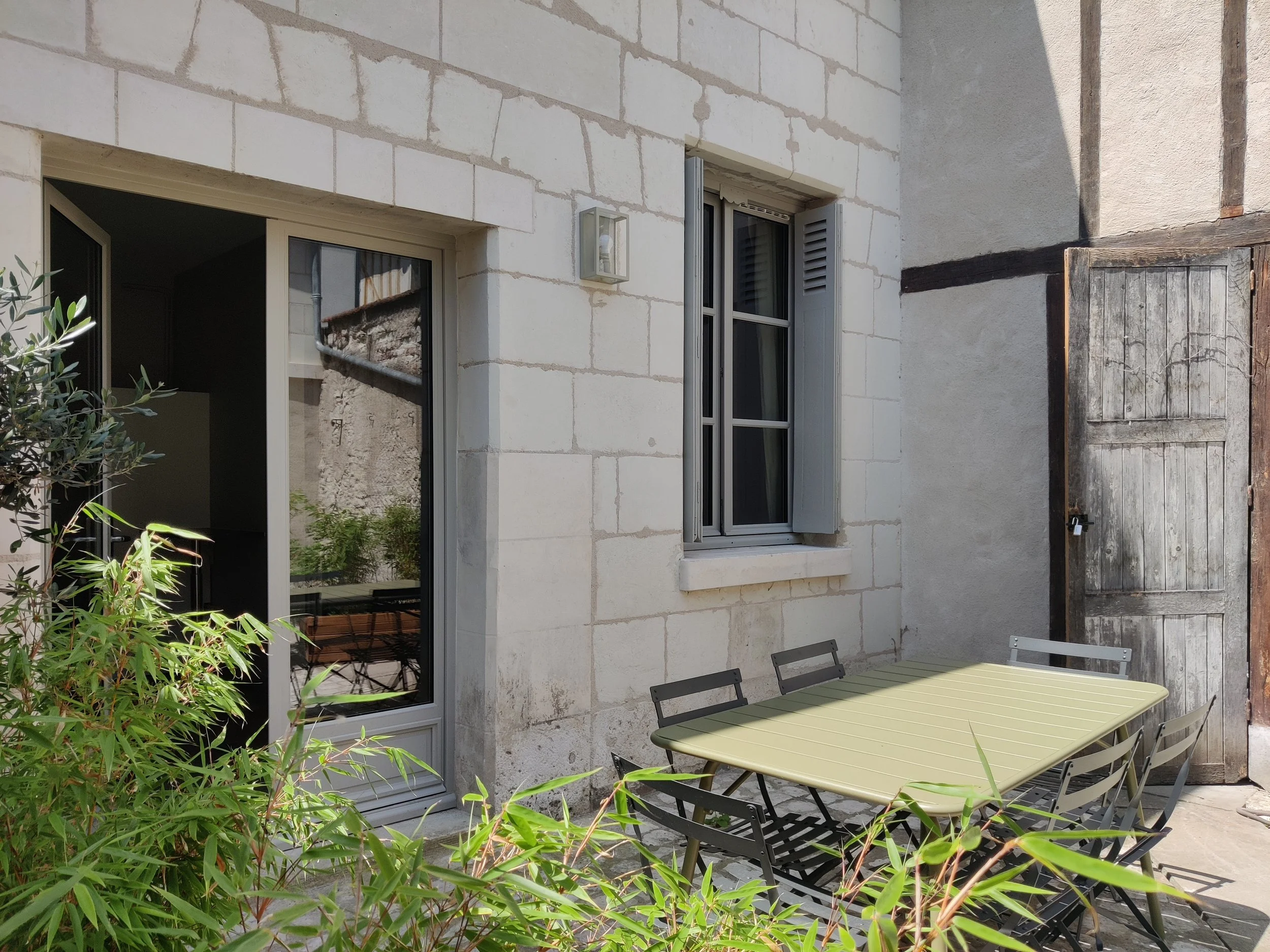 Outdoor patio with a table and chairs, potted plants