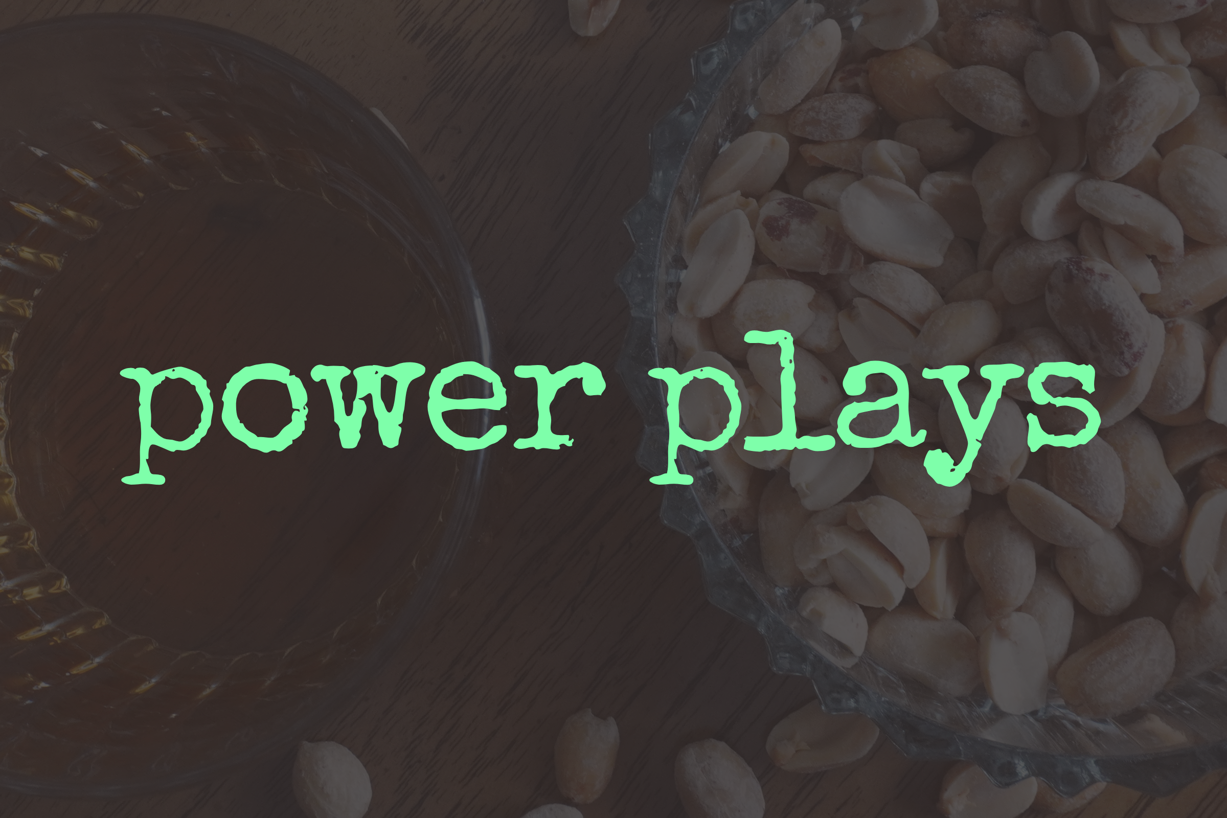 A photo of a glass bowl of peanuts and glass of whiskey with the word 'power plays' written across the center in bright green, stylized text.
