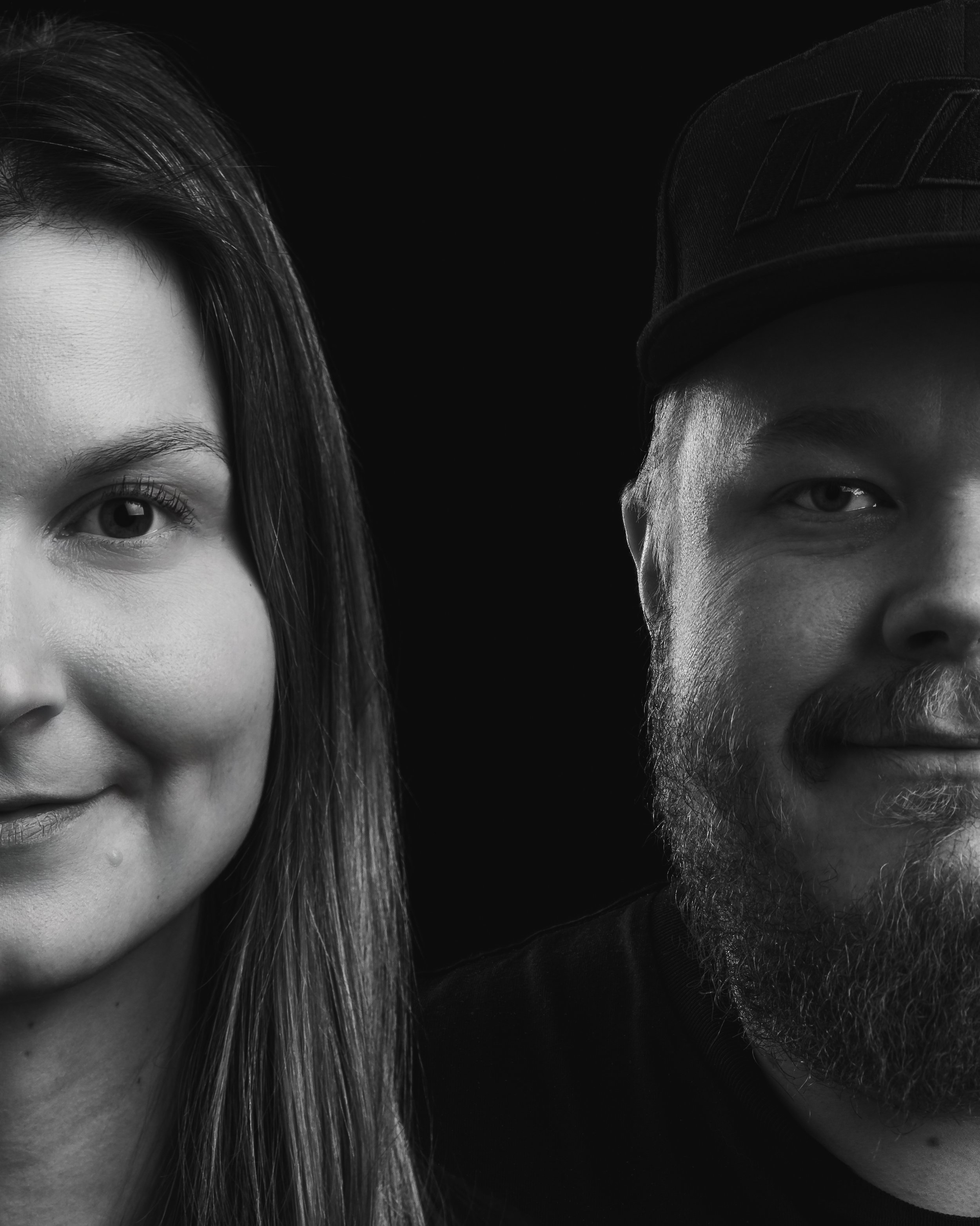 Mustavalkoinen kuva, jossa näkyy osa naisen ja miehen kasvoista, korva ja silmä, sekä hattu.