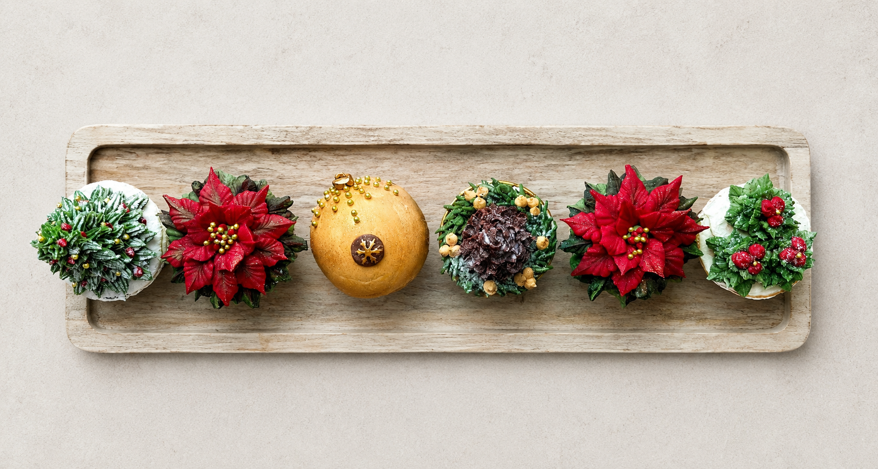 Hand-piped Christmas cupcakes featuring a realistic Christmas tree, red poinsettia, pine cone and festive holly leaves, handcrafted in Dublin by Full Bloom Bakehouse. Perfect for Christmas parties, holiday gifting, corporate Christmas events and fest