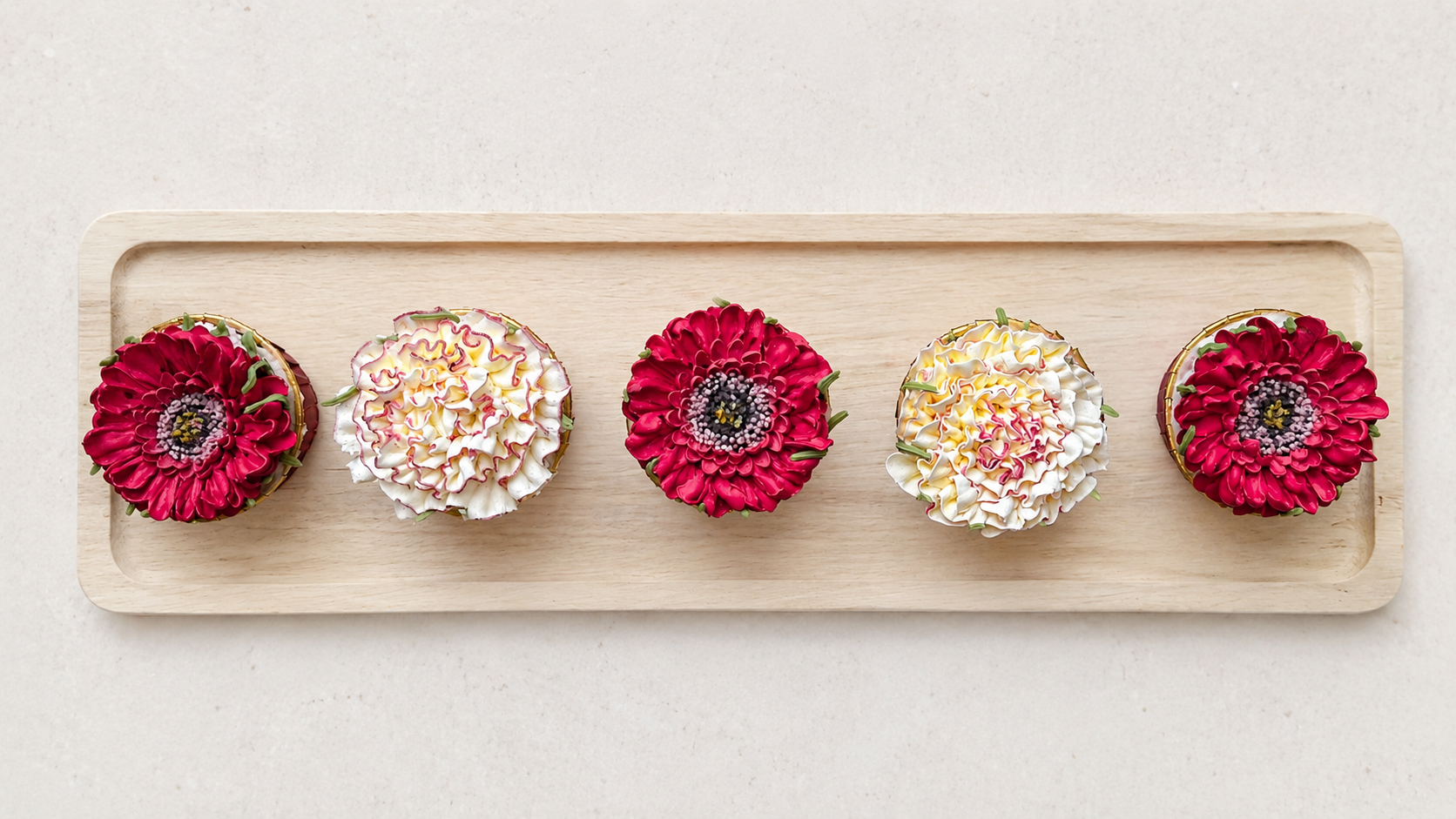 Hand-piped red and deep pink gerbera cupcakes paired with white and pink carnation buttercream flowers, handcrafted in Dublin by Full Bloom Bakehouse. A vibrant floral cupcake collection perfect for birthdays, celebrations, gifts and special occasion