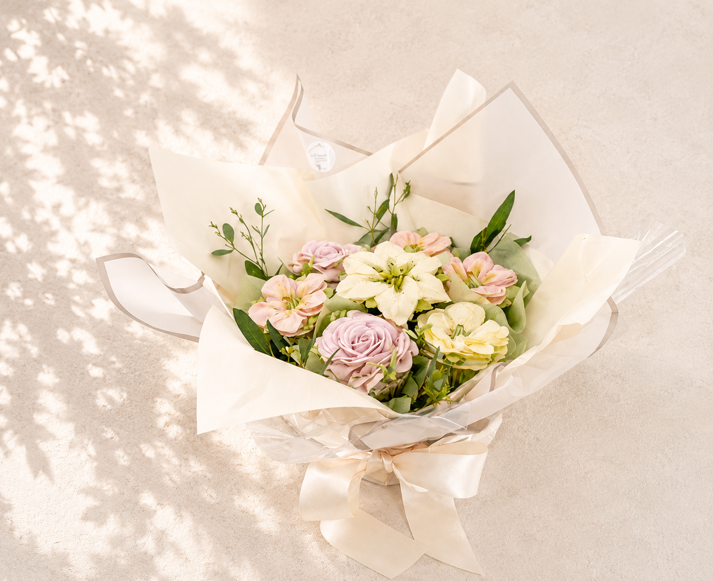 Seven-cupcake bouquet featuring hand-piped blush roses and white lilies, handcrafted in Dublin by Full Bloom Bakehouse. An elegant floral cupcake bouquet and luxury edible gift, perfect for birthdays, anniversaries, engagements, Mother’s Day and spec