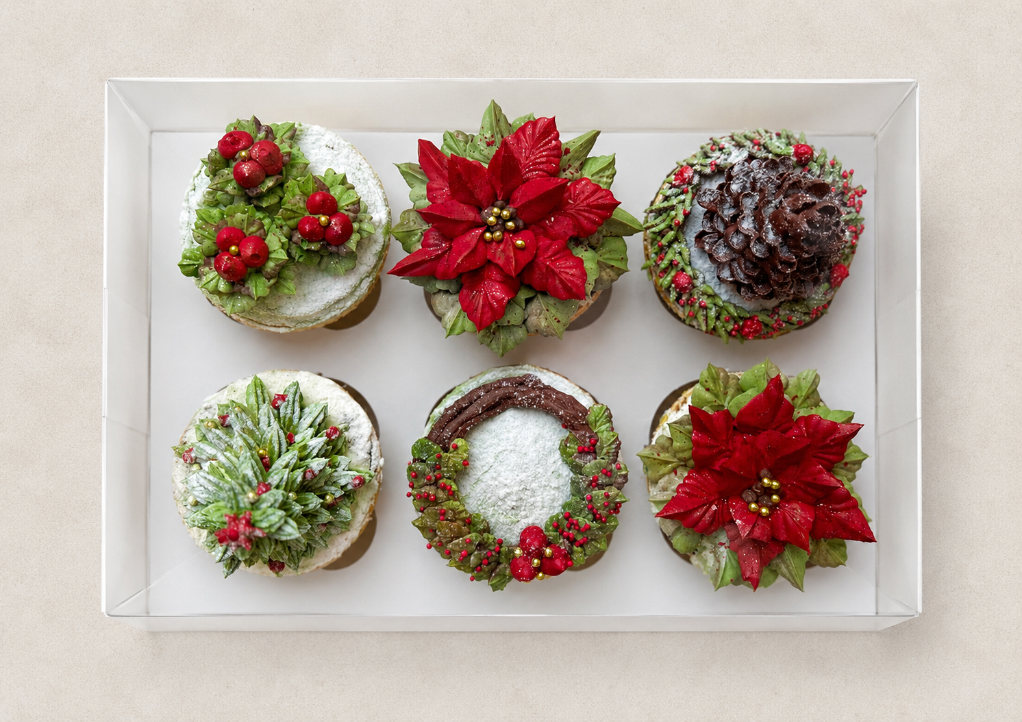 Hand-piped Christmas cupcakes featuring a realistic Christmas tree, a festive wreath with red winter berries, a red poinsettia, a 3D pine cone and a light dusting of snow, handcrafted in Dublin by Full Bloom Bakehouse. Perfect for Christmas celebrati