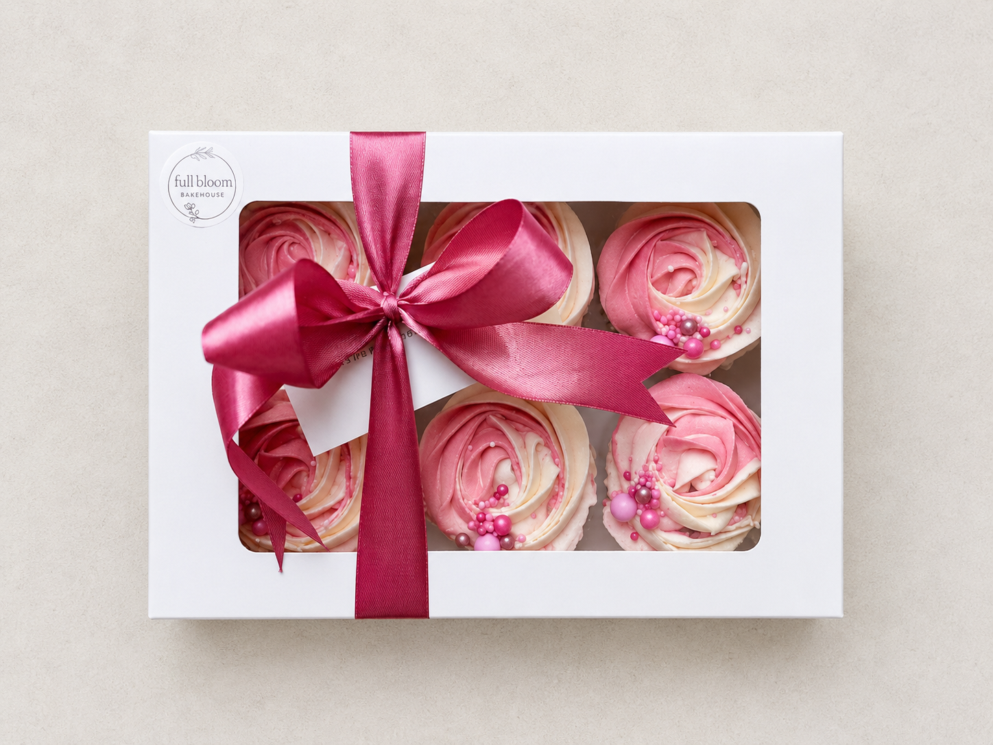 Elegant swirl cupcakes decorated with cream and blush pink buttercream rosettes and finished with pearl sprinkles, handcrafted in Dublin by Full Bloom Bakehouse. Perfect for baby girl birthdays, baby showers, gender reveal parties, “It’s a Girl” cele