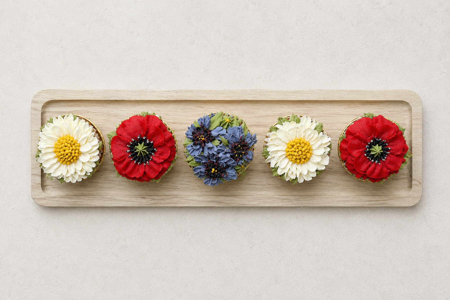 Hand-piped wildflower cupcakes featuring red poppies, blue cornflowers and white daisies, handcrafted in Dublin by Full Bloom Bakehouse. Inspired by traditional Polish meadow flowers, these luxury floral cupcakes are perfect for birthdays, summer cel