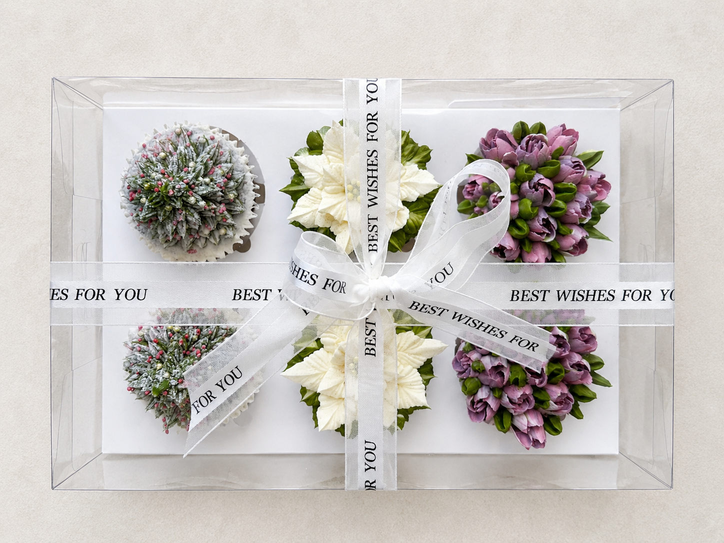 Hand-piped Christmas cupcakes featuring a realistic 3D Christmas tree, white poinsettia and lilac tulip buttercream flowers, handcrafted in Dublin by Full Bloom Bakehouse. Perfect for Christmas celebrations, festive gifting, corporate Christmas event