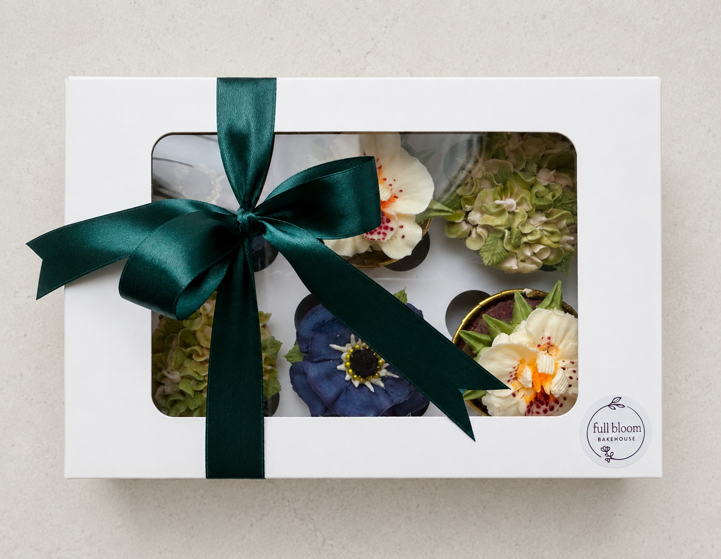 Hand-piped deep navy blue anemone and white orchid cupcakes, handcrafted in Dublin by Full Bloom Bakehouse. A sophisticated floral cupcake collection with elegant masculine styling, perfect for birthdays, corporate gifting and special celebrations fo