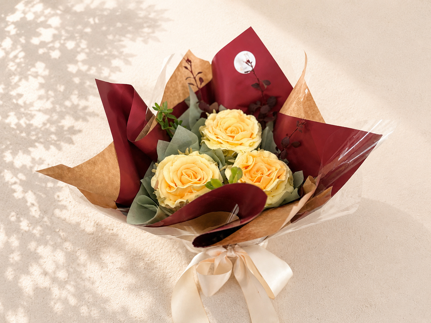 Three-cupcake bouquet featuring hand-piped yellow buttercream roses, wrapped in kraft and burgundy paper and handcrafted in Dublin by Full Bloom Bakehouse. A luxury edible gift and beautiful alternative to fresh flowers, perfect for birthdays, thank 
