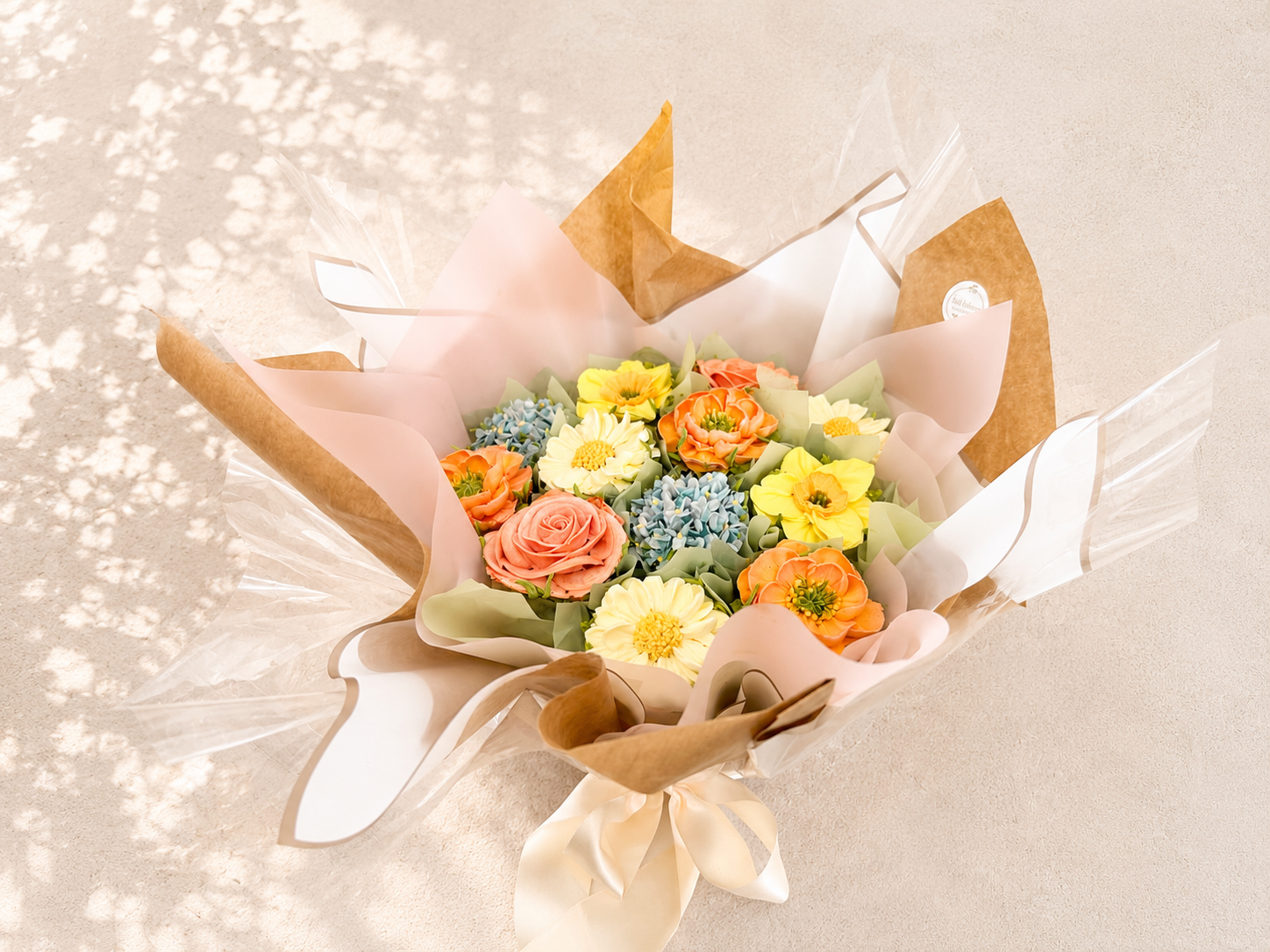 Hand-piped daffodil, daisy, blue hydrangea, rose and orange poppy cupcake bouquet, handcrafted in Dublin by Full Bloom Bakehouse. Featuring a variety of realistic buttercream flowers and filled cupcakes, this luxury cupcake bouquet is perfect for bir
