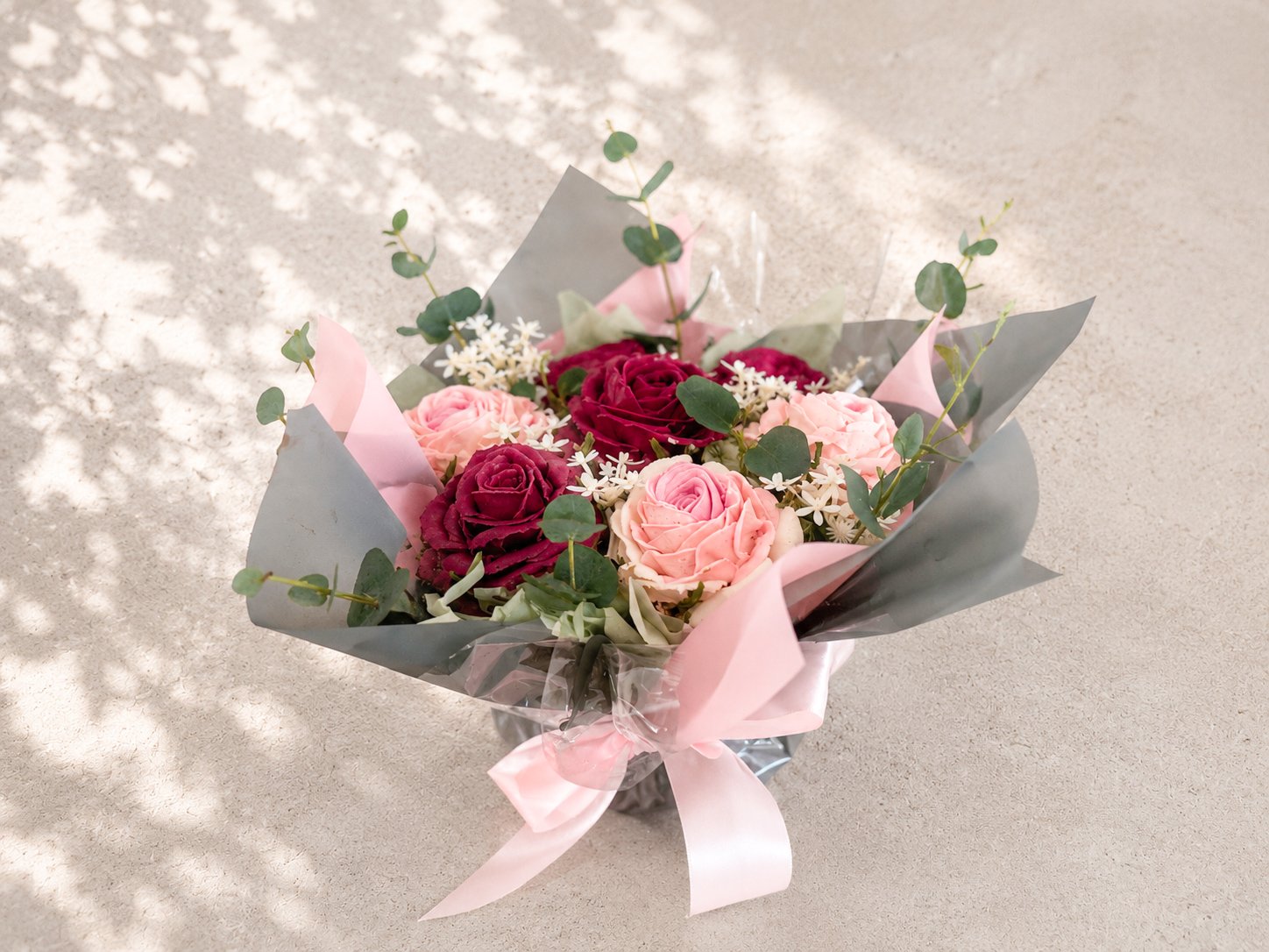 Seven-cupcake bouquet featuring hand-piped blush and deep pink roses with fresh eucalyptus, handcrafted in Dublin by Full Bloom Bakehouse. A luxury edible gift designed to resemble a fresh flower bouquet, perfect for birthdays, Mother’s Day, annivers