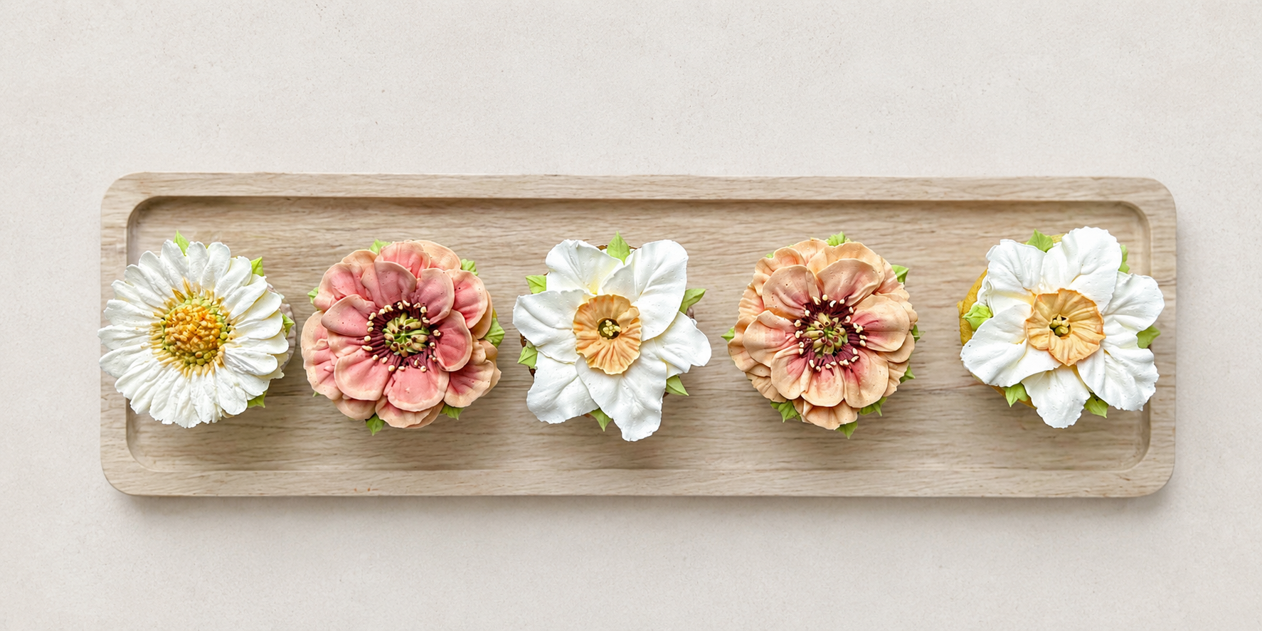 Hand-piped orange poppy, white daisy and white daffodil cupcakes, handcrafted in Dublin by Full Bloom Bakehouse. Featuring realistic buttercream flowers in a fresh spring colour palette, these luxury floral cupcakes are perfect for birthdays, Easter 