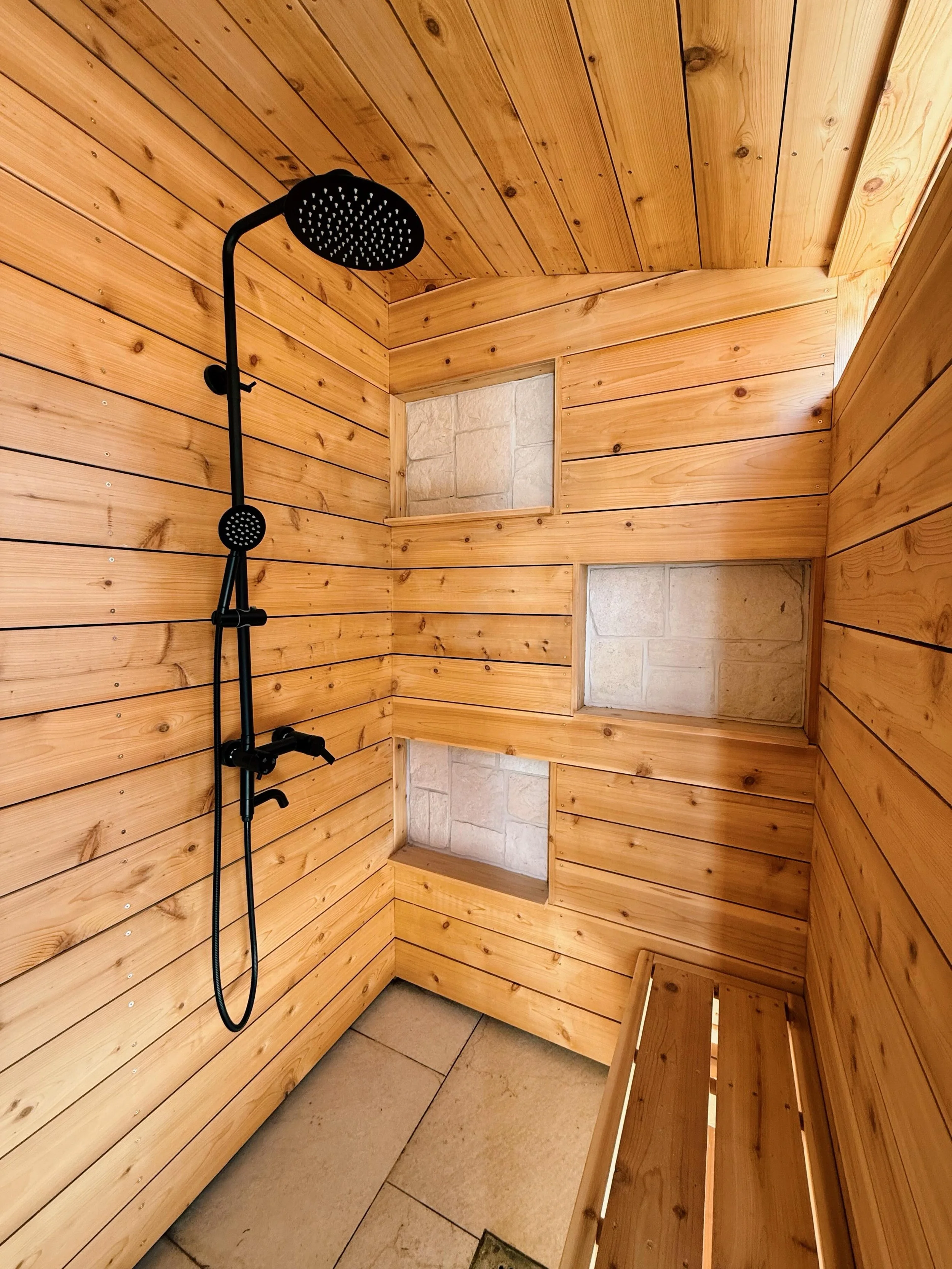 Cedar outdoor shower at a beautiful home built by @sandbarcontractors