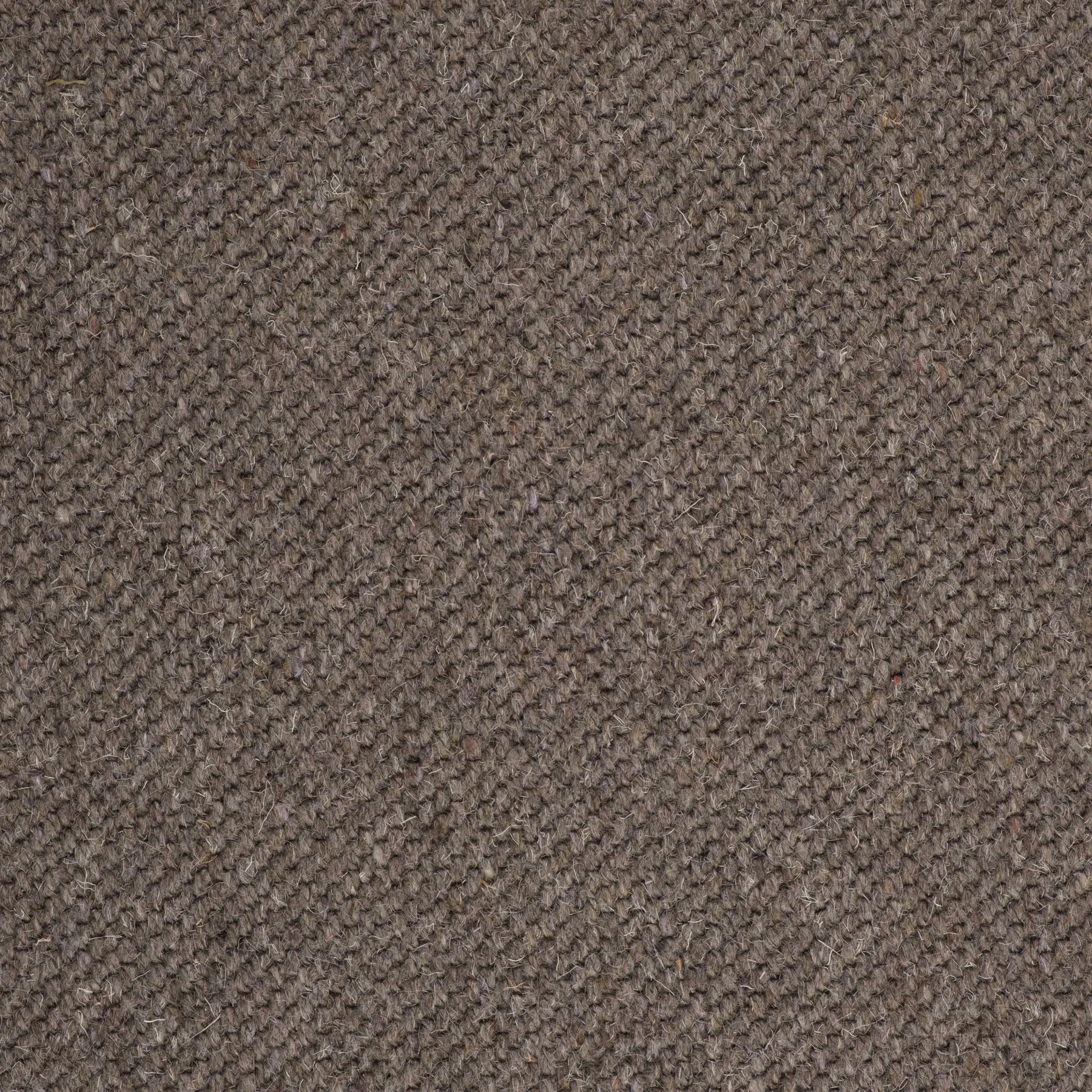 Close-up of a brown, textured fabric surface, possibly upholstery or carpeting.