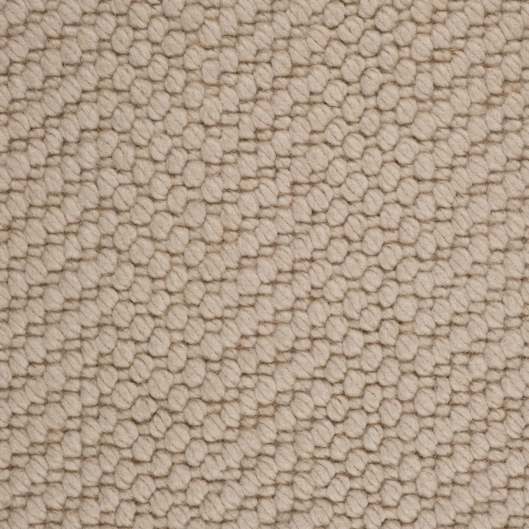 Close-up view of beige textured carpet with small loops and diagonal pattern.