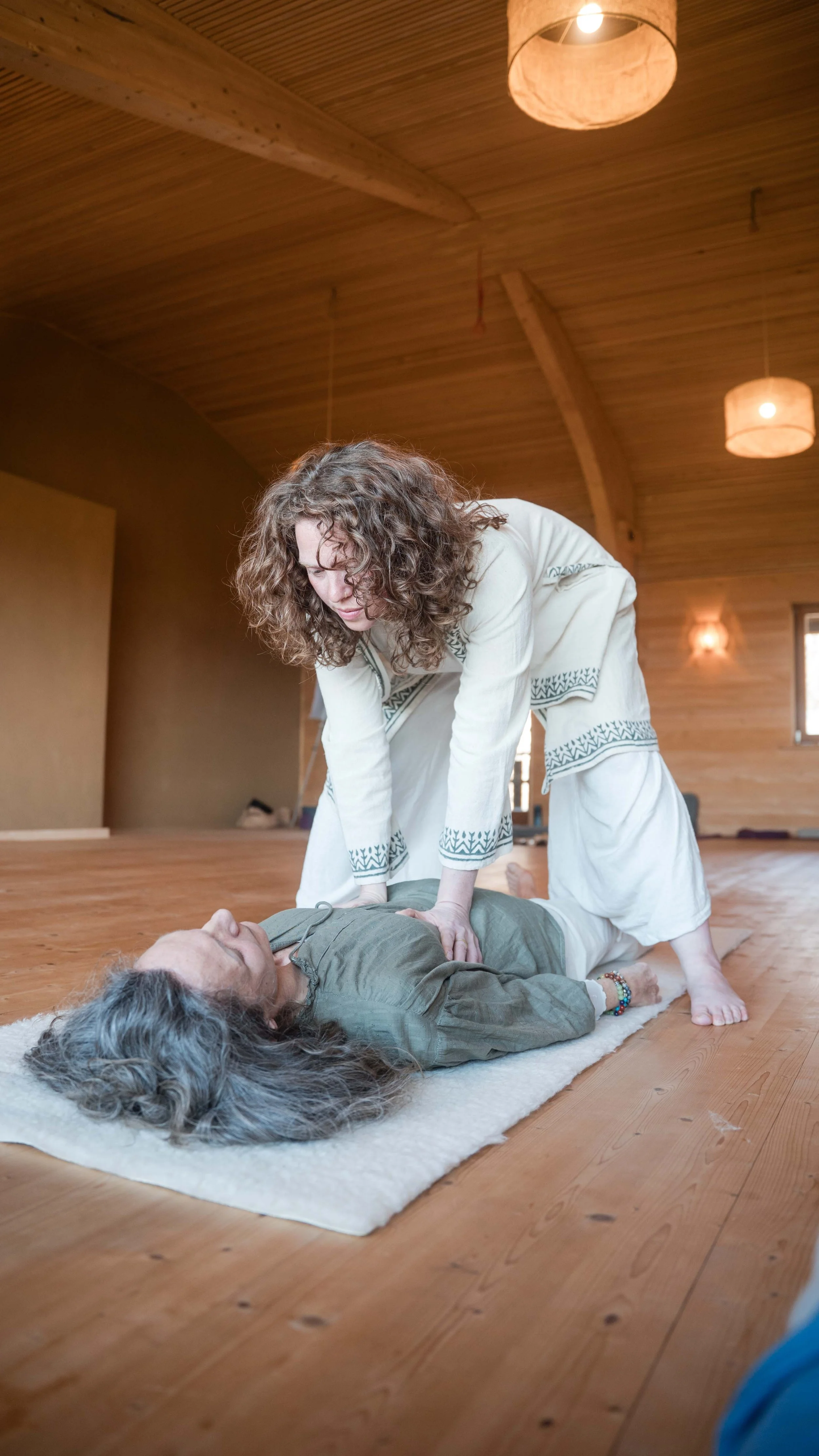 zwei Frauen üben die Herz-Lungen-Wiederbelebung in einem Holzraum