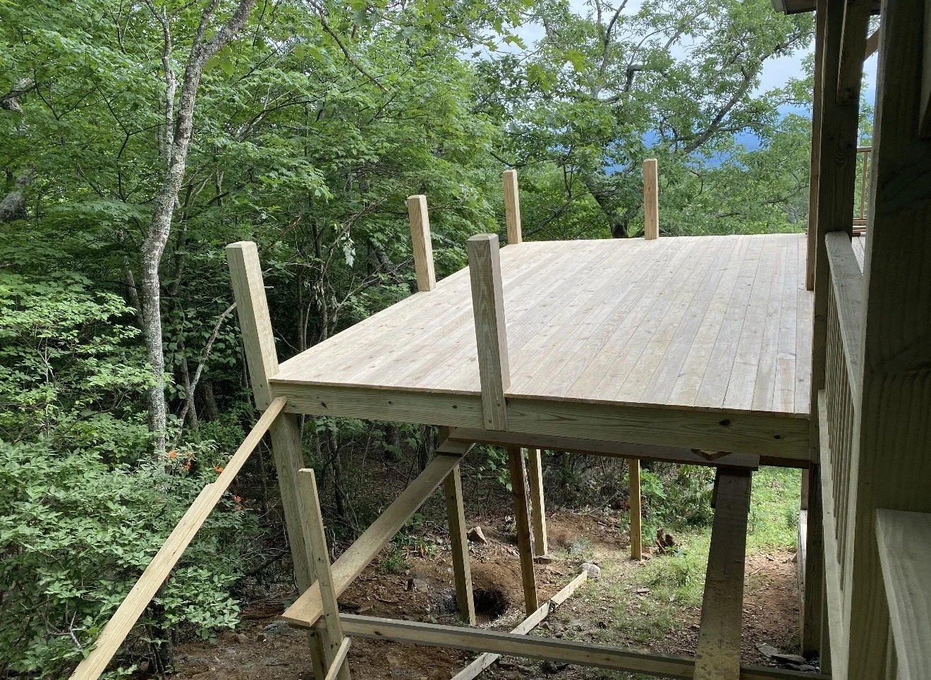 Wooden deck construction in progress on a hillside, by Antonio's Construction serving Ashe and Watauga County in North Carolina.