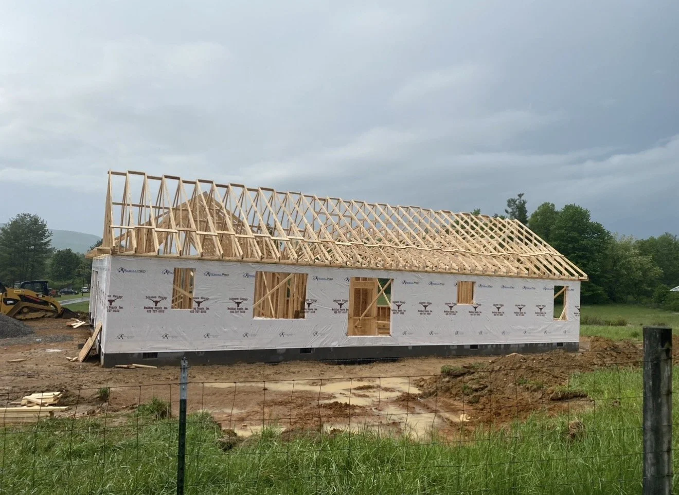 A house under construction with wooden framing and a partially built roof by Antonio's Construction serving Ashe and Watauga County in North Carolina.