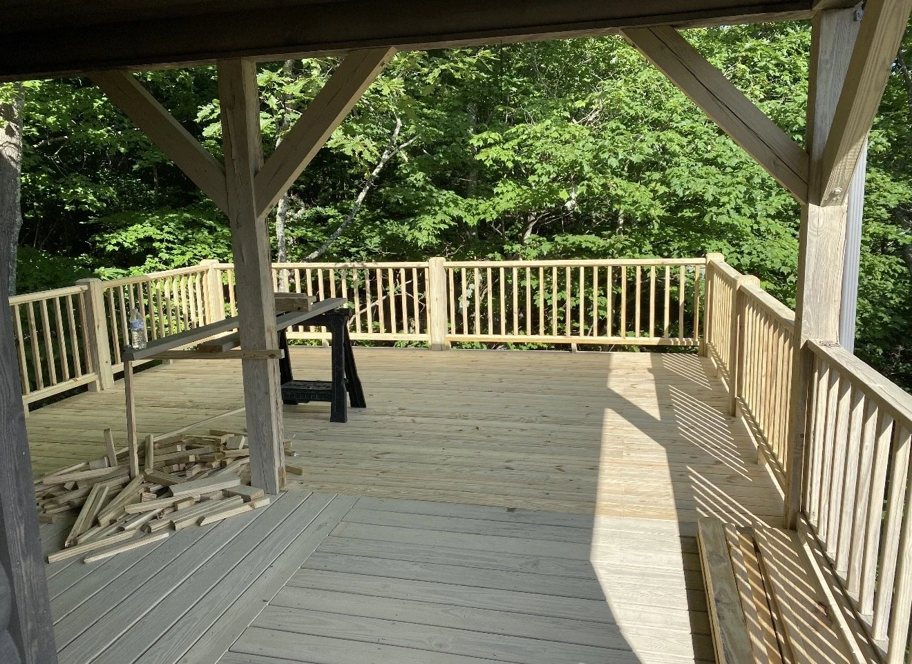 A partially built wooden deck with railings, construction materials, by Antonio's Construction serving Ashe and Watauga County in North Carolina.