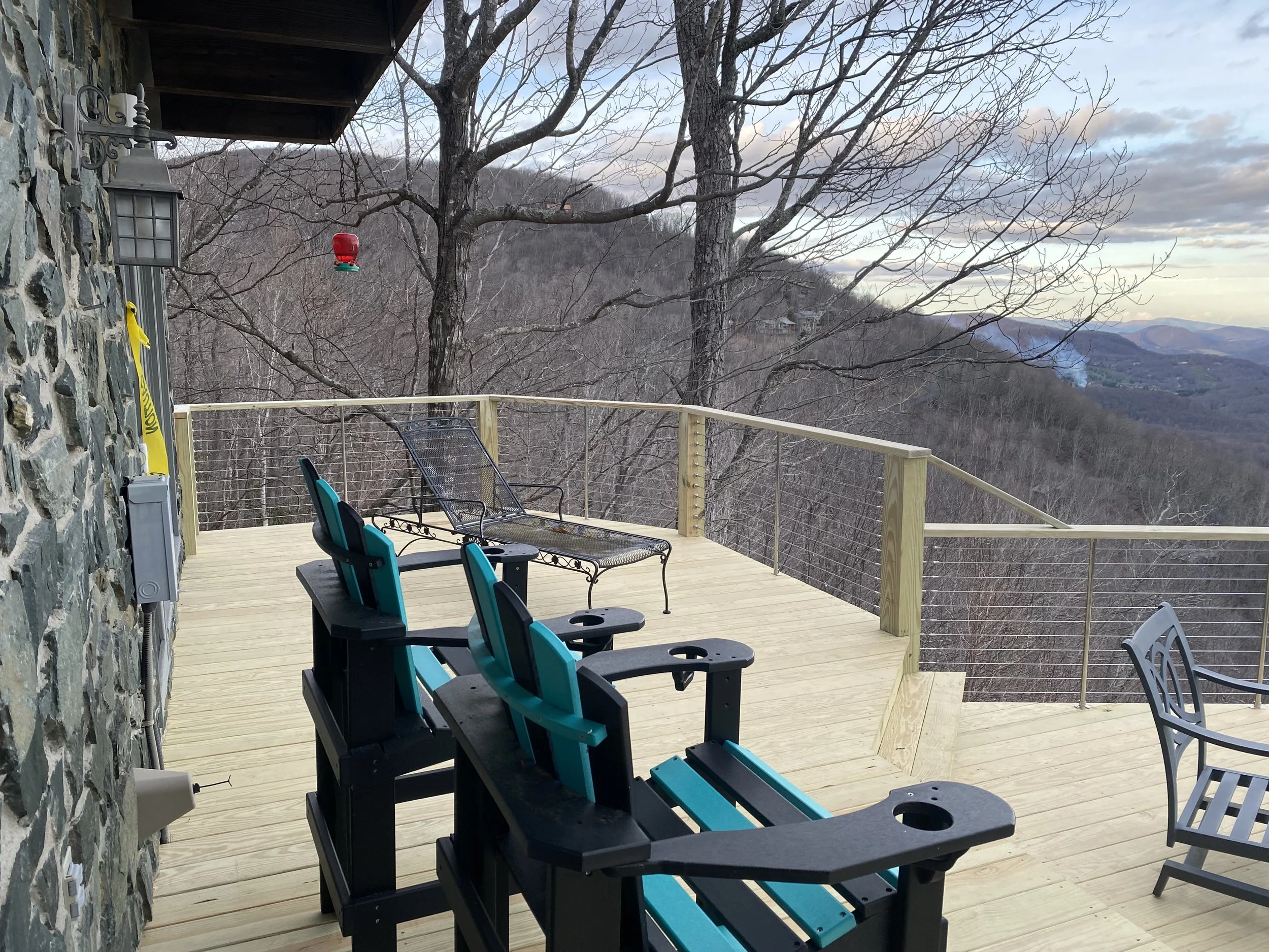 View of a wooden deck with outdoor chairs by Antonio’s Construction providing exterior construction in Ashe County and Watauga County, NC