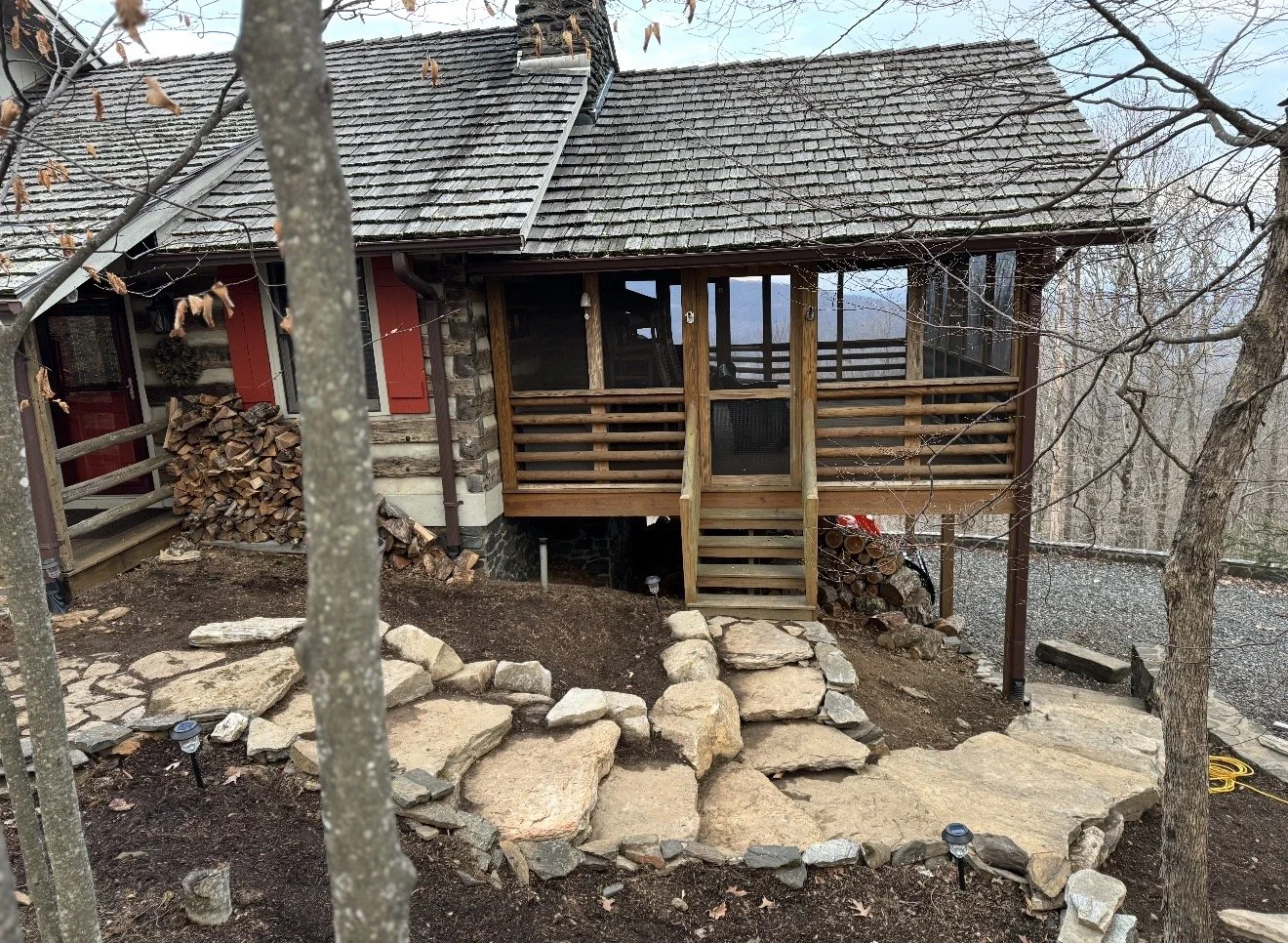 A rustic cabin with stone and wood exterior by Antonio's Construction serving Ashe and Watauga County in North Carolina.