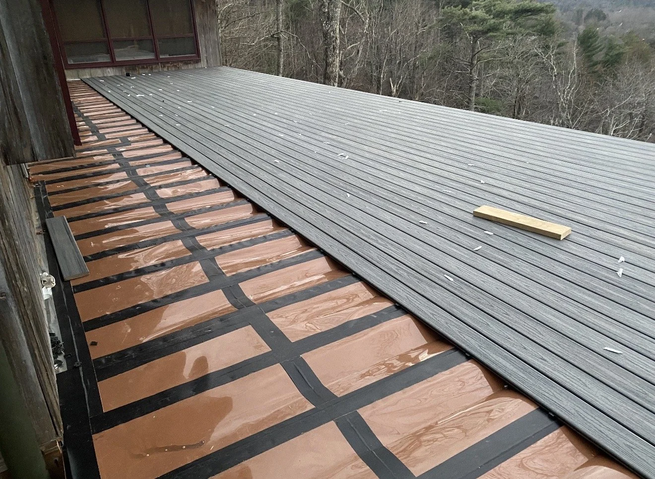 A roof with underlayment and new metal roofing panels being installed, by Antonio's Construction serving Ashe and Watauga County in North Carolina.